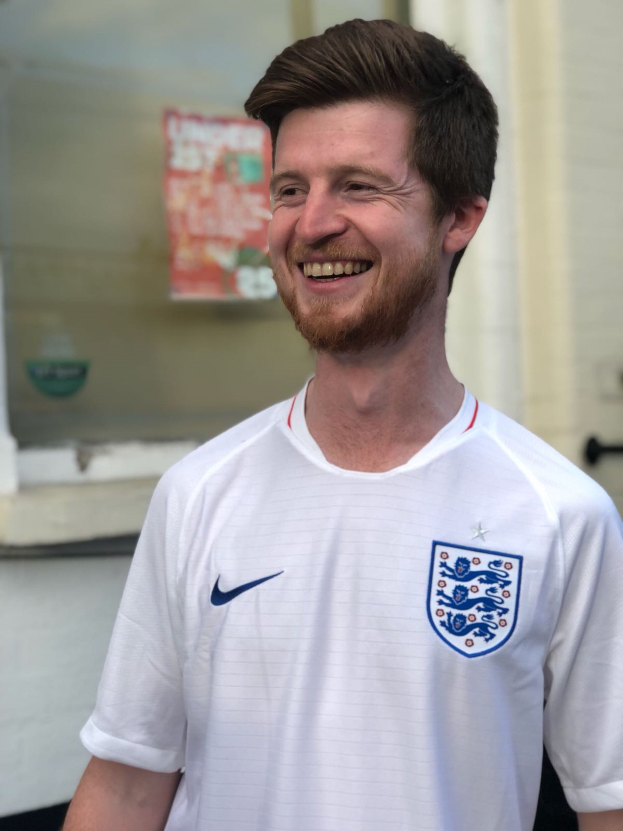 Alex taking in an England victory during the 2018 World Cup. He's wearing a white England football shirt and is beaming. Photo supplied.JPG