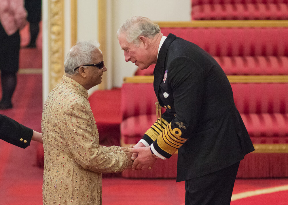 Baluji shaking hands with Prince Charles at his Investiture as OBE. Photo supplied