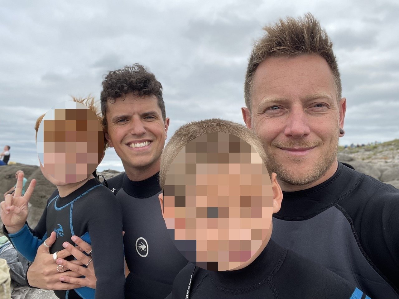 Andrew and Damian on a Christmas morning swim with their boys. All four are pictured in black wet suits. Photo: Damian Kerlin
