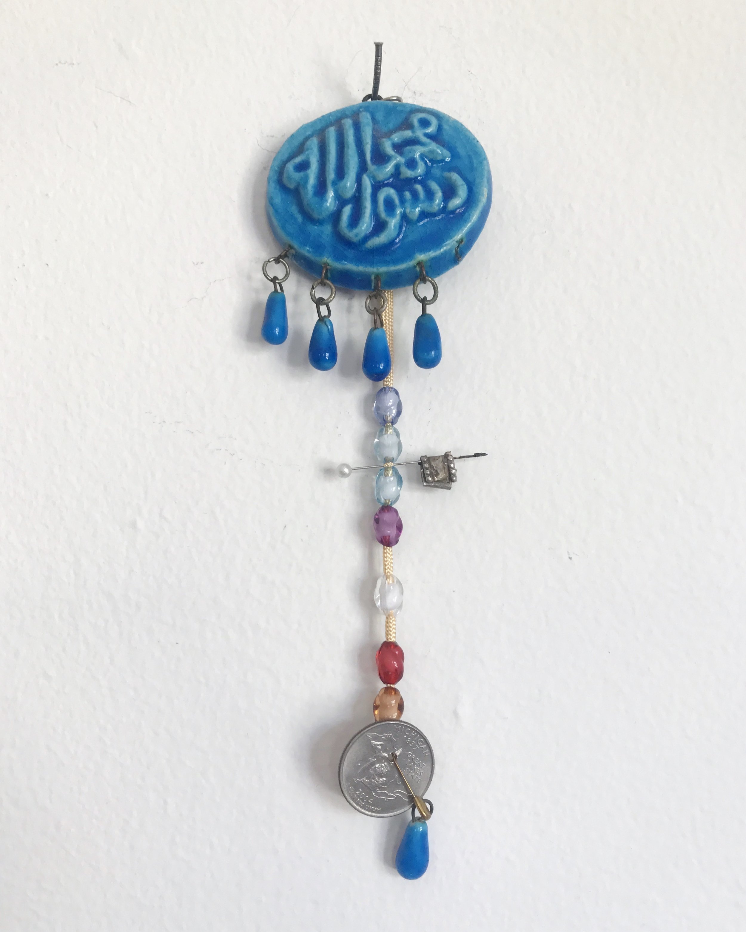  2015  ceramic coin, ceramic sequins, dressmaker pin, plastic beads from Mecca, Saudi Arabia, United States currency (Michigan edition quarter) 