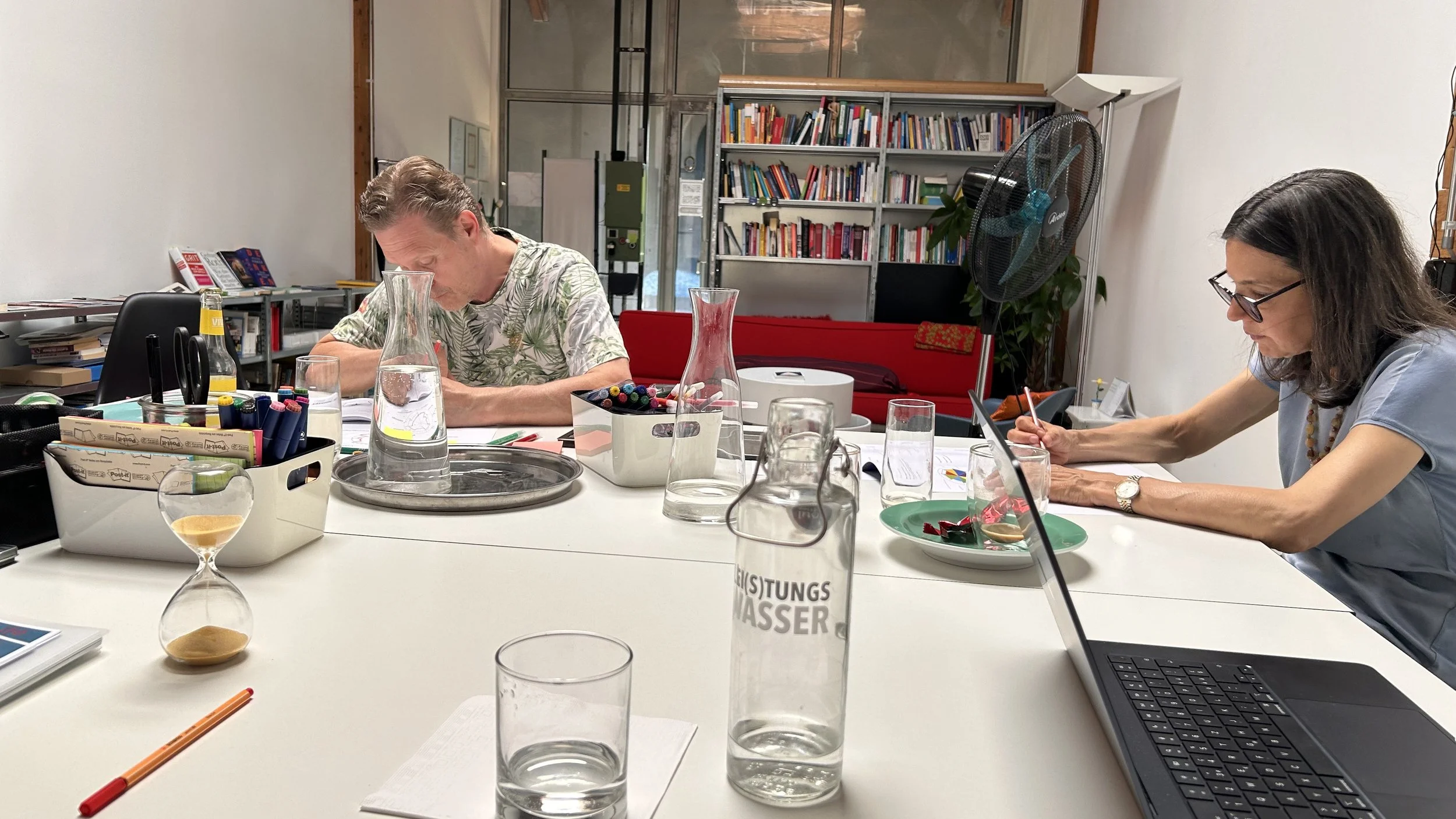 Teilnehmende arbeiten konzentriert am Tisch im Plan C' Atelier während eines Design-Your-Life-Workshops