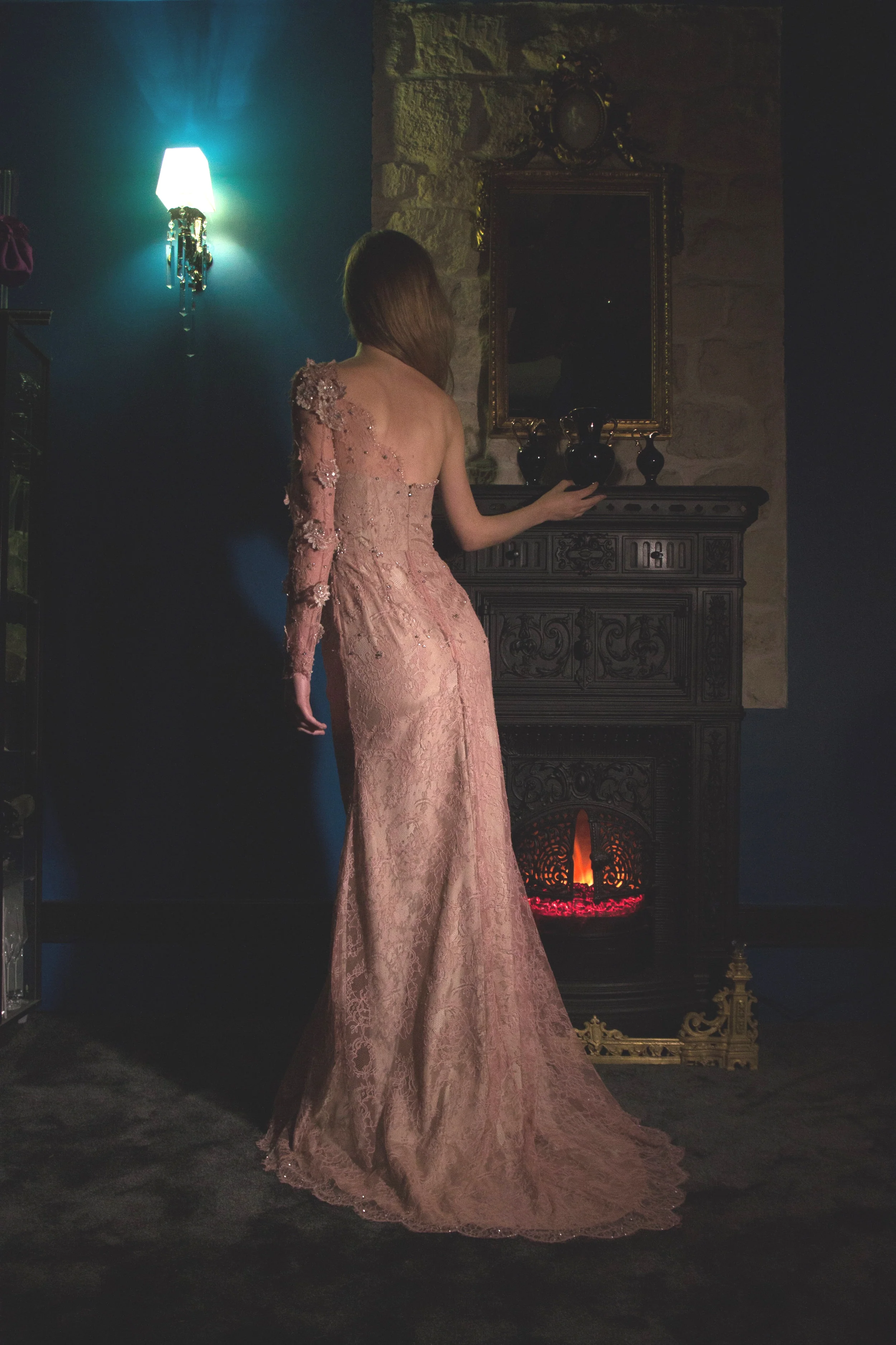 MANON.Robe princesse asymétrique en dentelle rose parsemée de fleurs brodées de mousse de paillettes carrées et de strass Swarovsky. Les fleurs en soulevées sur la manche donne l’impression d’un jardin fleuri.