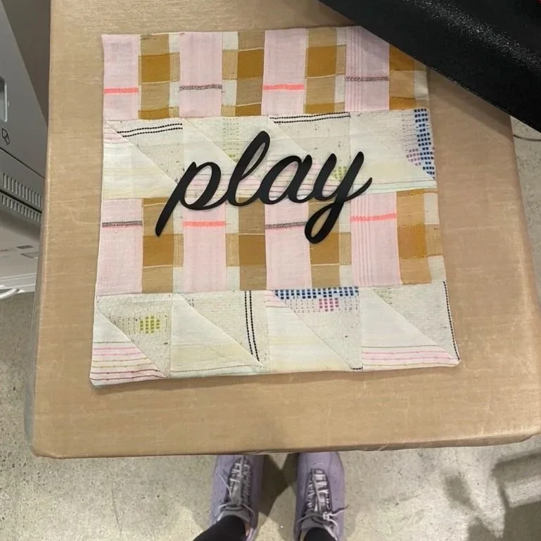 Quilted reclaimed fabric with heat pressed, laser cut vinyl