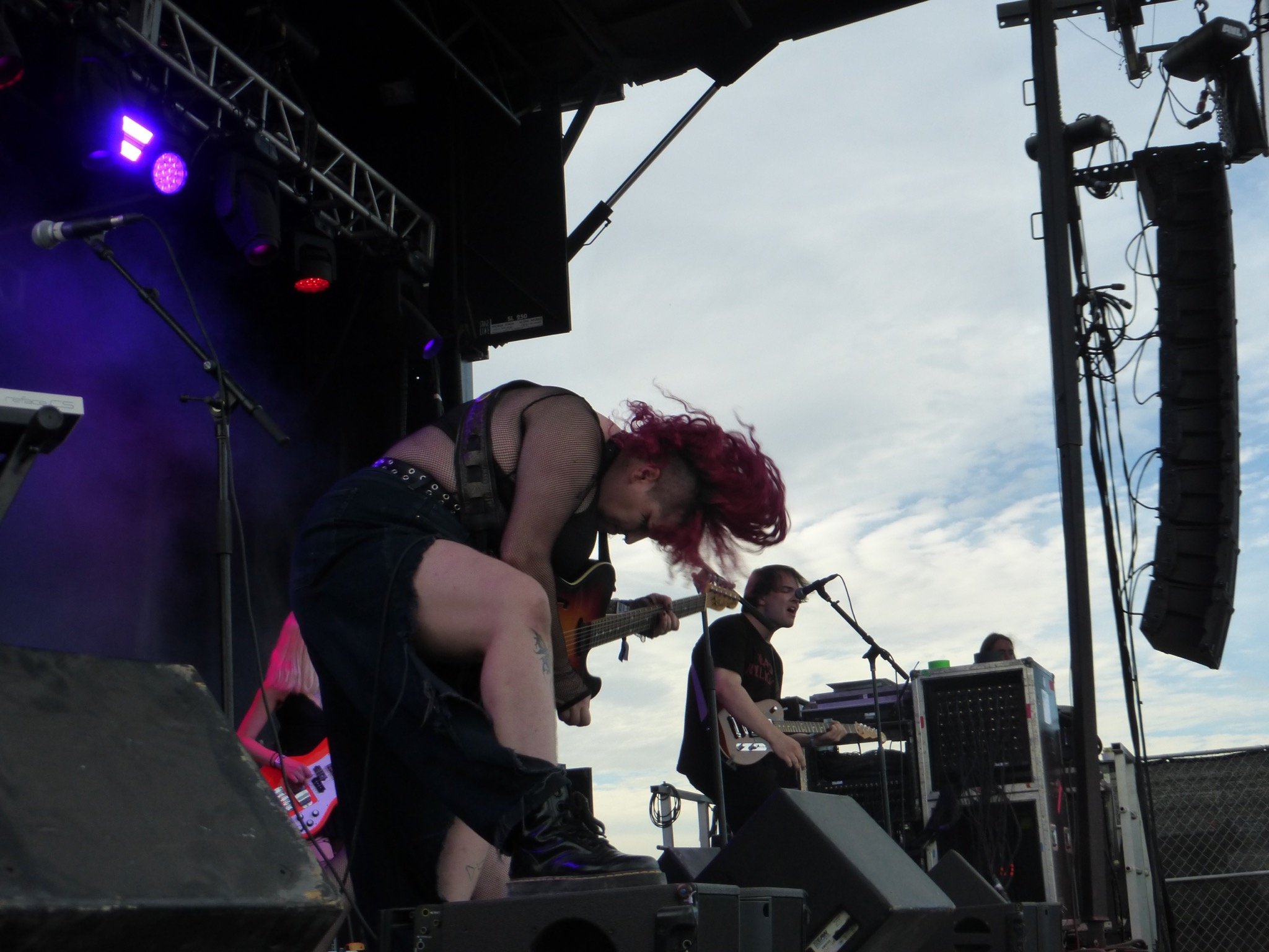 a rocker hunched over a guitar on a stage