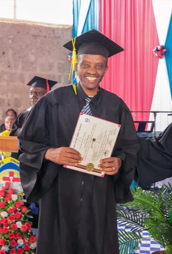 A Kenyan graduate shows his graduation certificate.