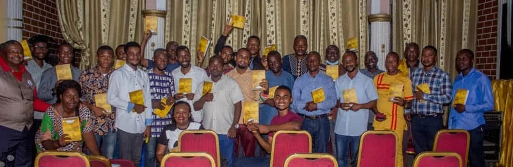 Pastors and church leaders in West Africa holding their French-language BTCP training manuals during a class session.