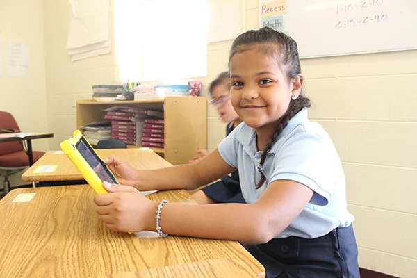 A UCP Downtown/BETA student using her iPad to interact with lesson plans.