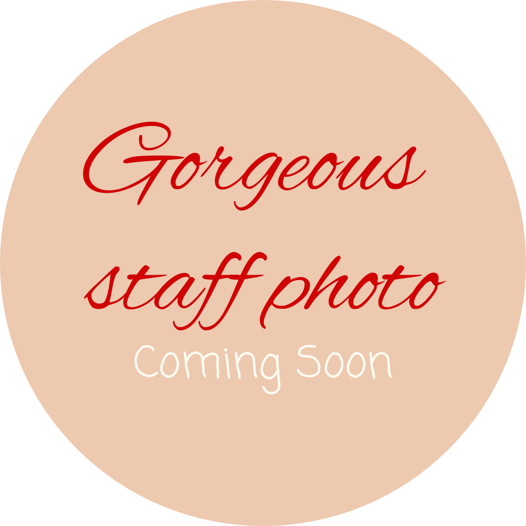 A beige circular sign with red cursive text that says 'Gorgeous staff photo' and white text underneath that says 'Coming Soon'.