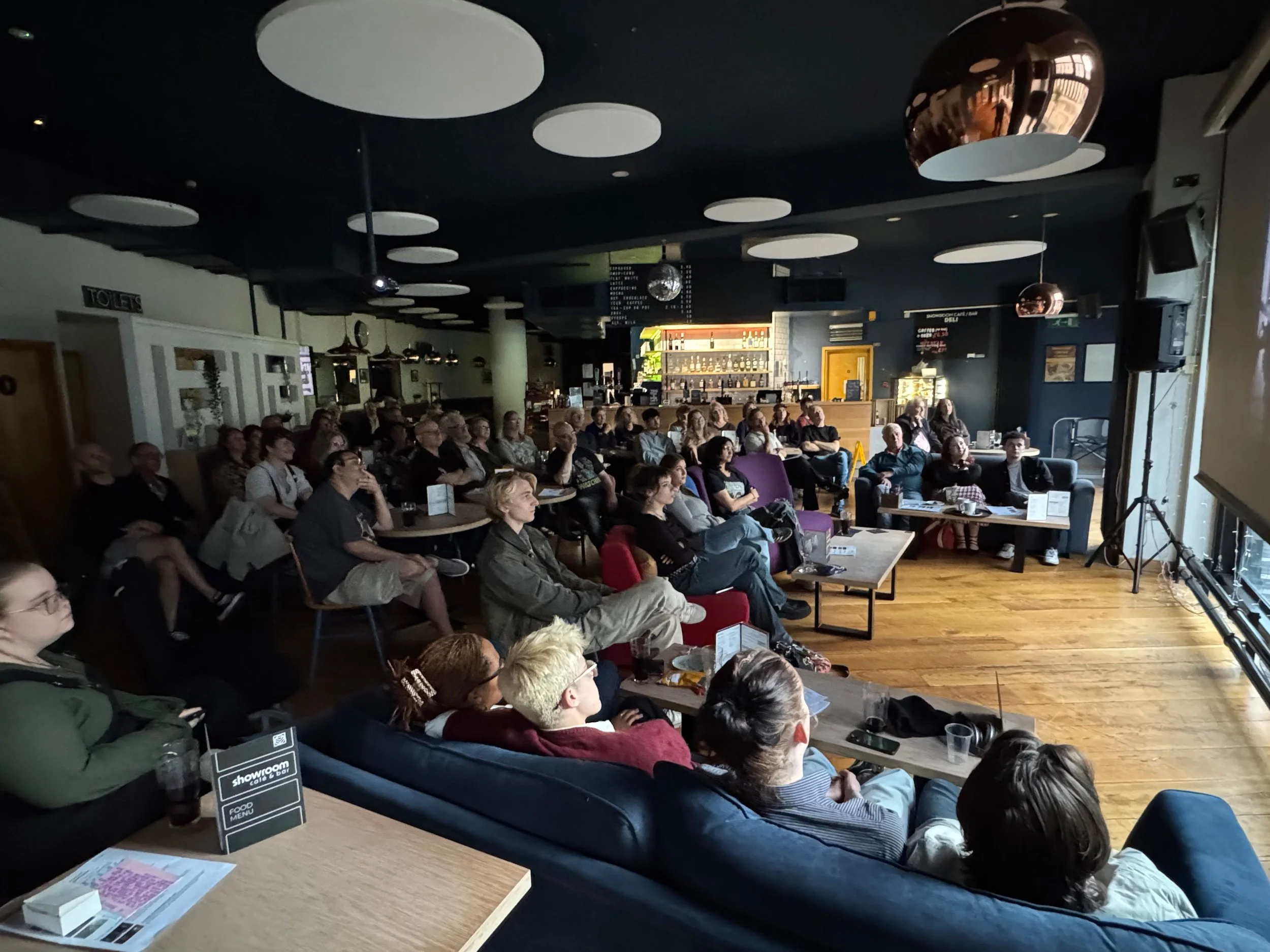 Group of people watching a film screening at SYFN's Showroom Shorts event.