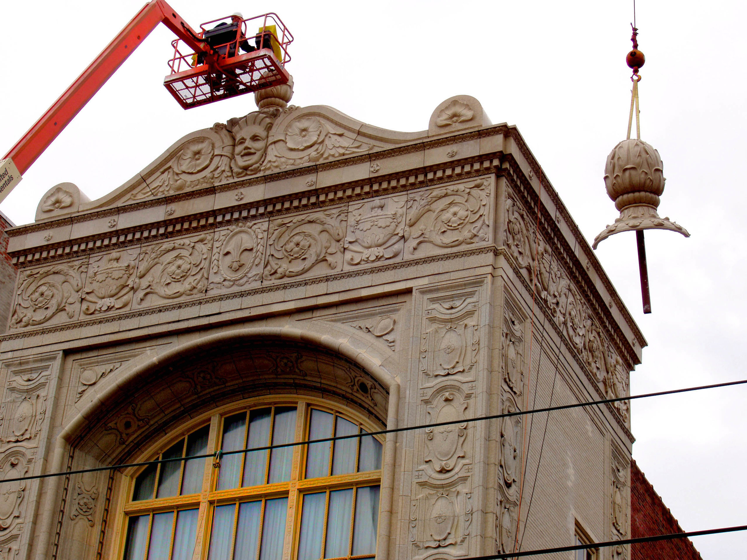  A man on a construction lift hovers over the sculptural roof elements of Sheas theatre in Buffalo New york. 