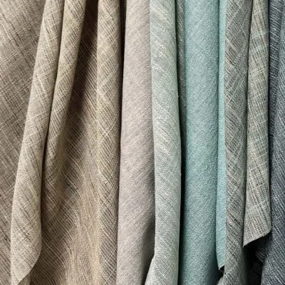 A row of hanging fabric swatches in neutral and muted colors with various patterns.