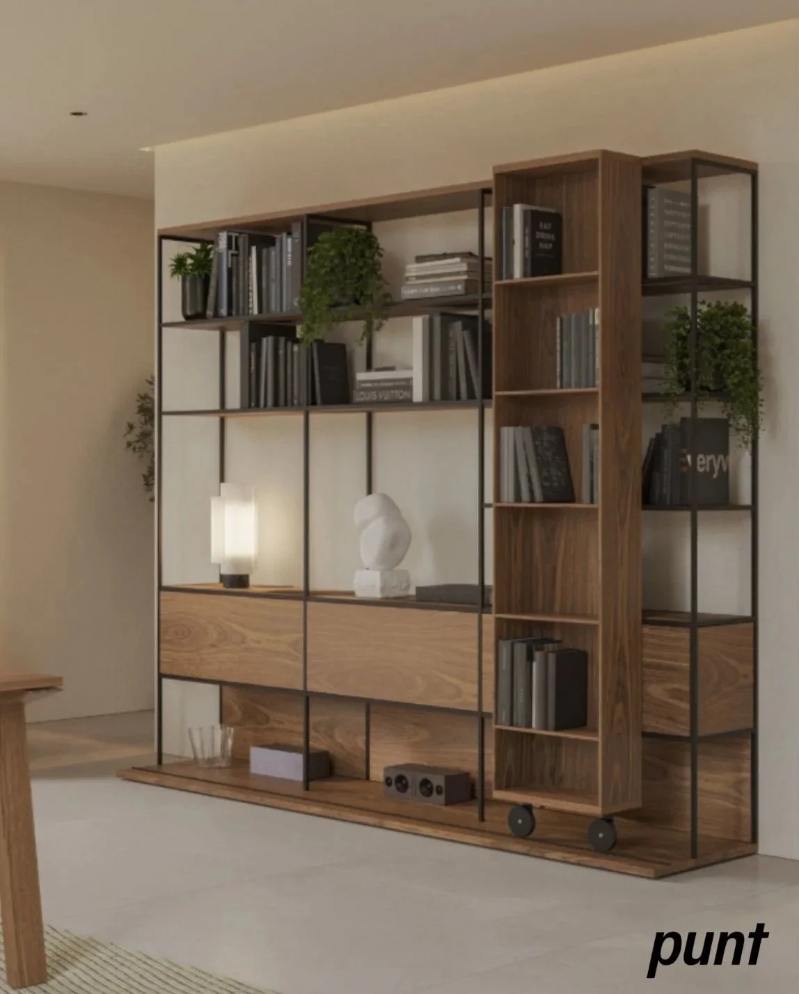 Modern open bookshelf with black metal frame, filled with books, plants, decorative objects, and a lamp, positioned against a white wall in a living room.
