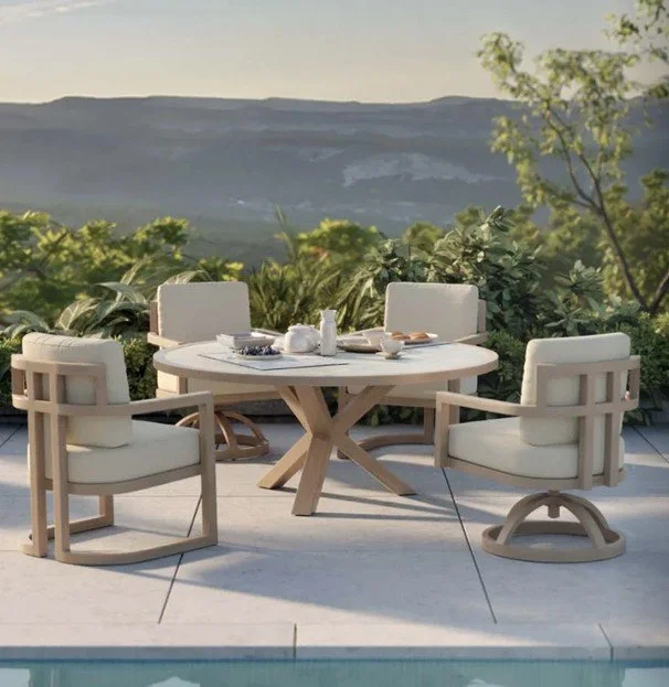Outdoor patio with a round table and four outdoor chairs, set against a scenic mountain landscape with greenery and trees.