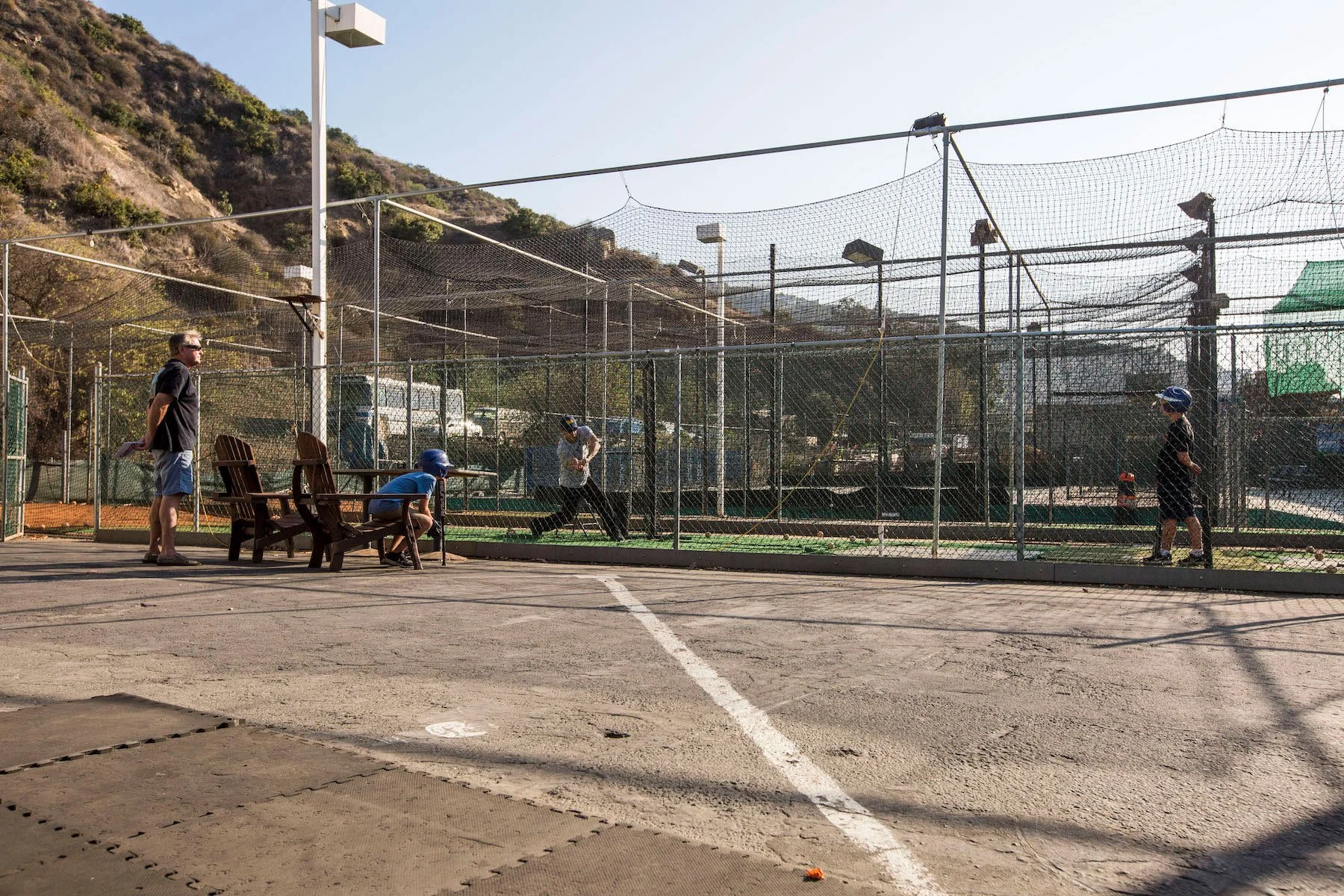 Jerry Rootlieb looks on while his grandson gets batting lessons from Neufeld