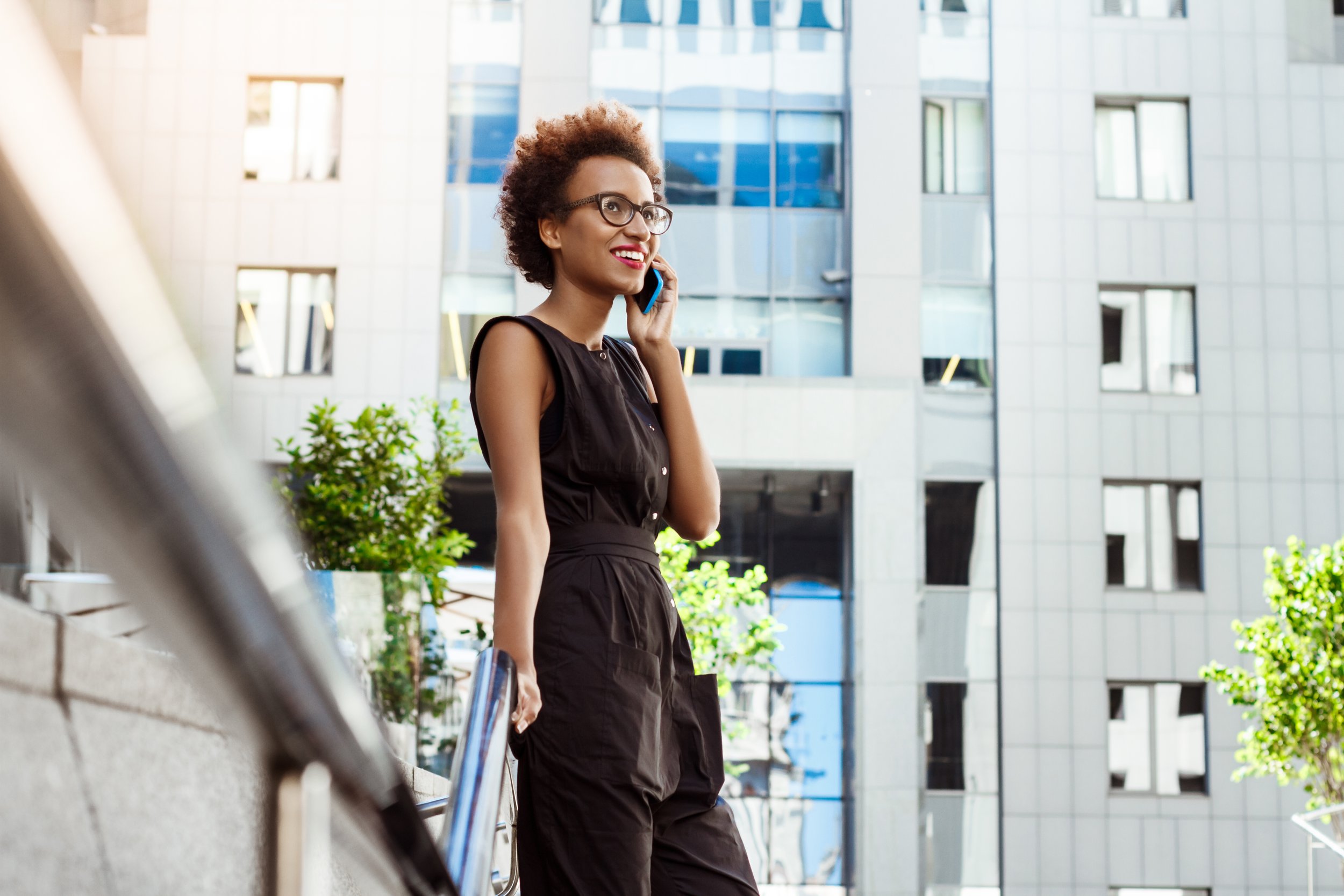 beautiful-woman-smiling-speaking-phone-walking-down-city.jpg