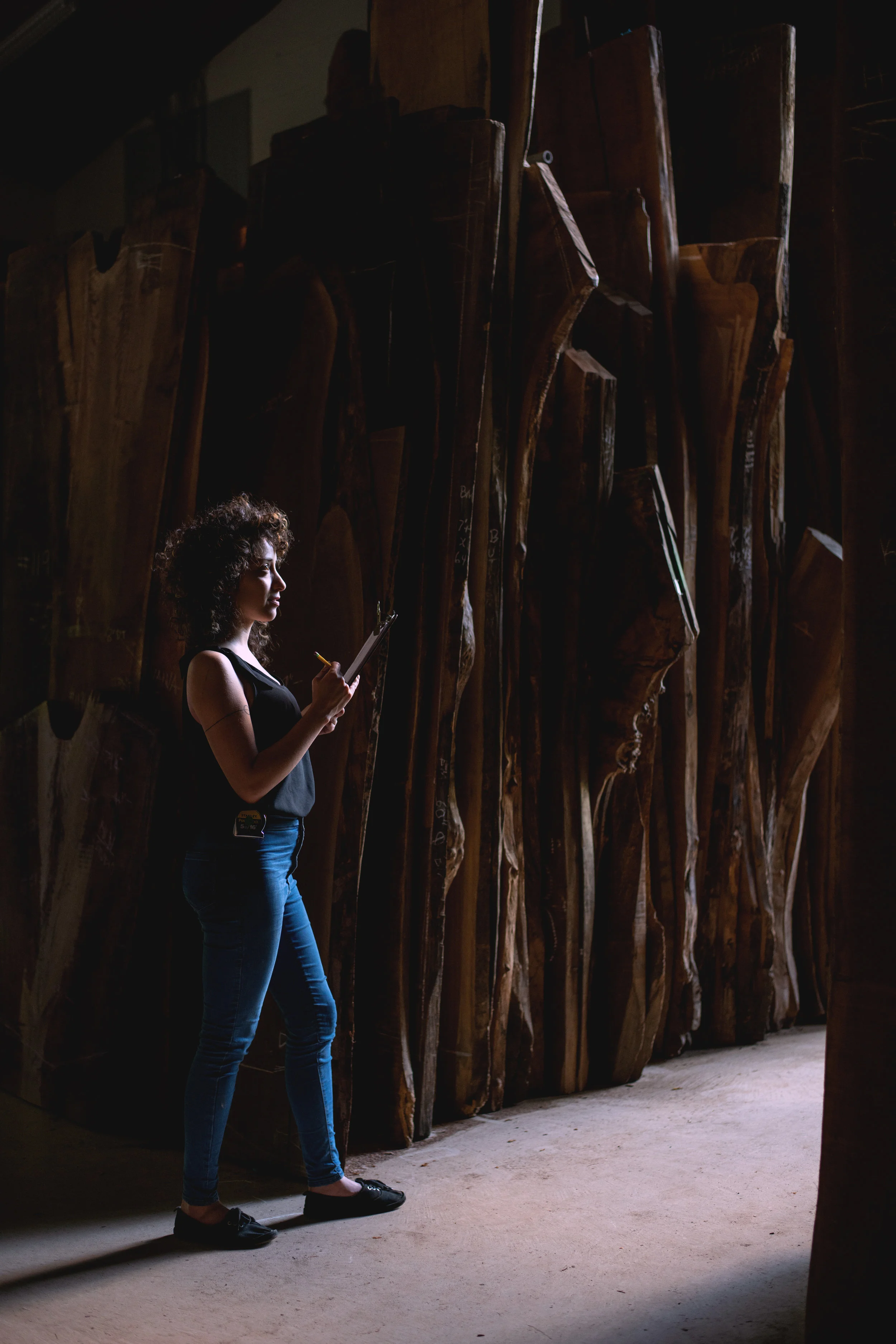 Alexis Rosa Caldero, designer craftsperson, sketching wood in a  lumber shed