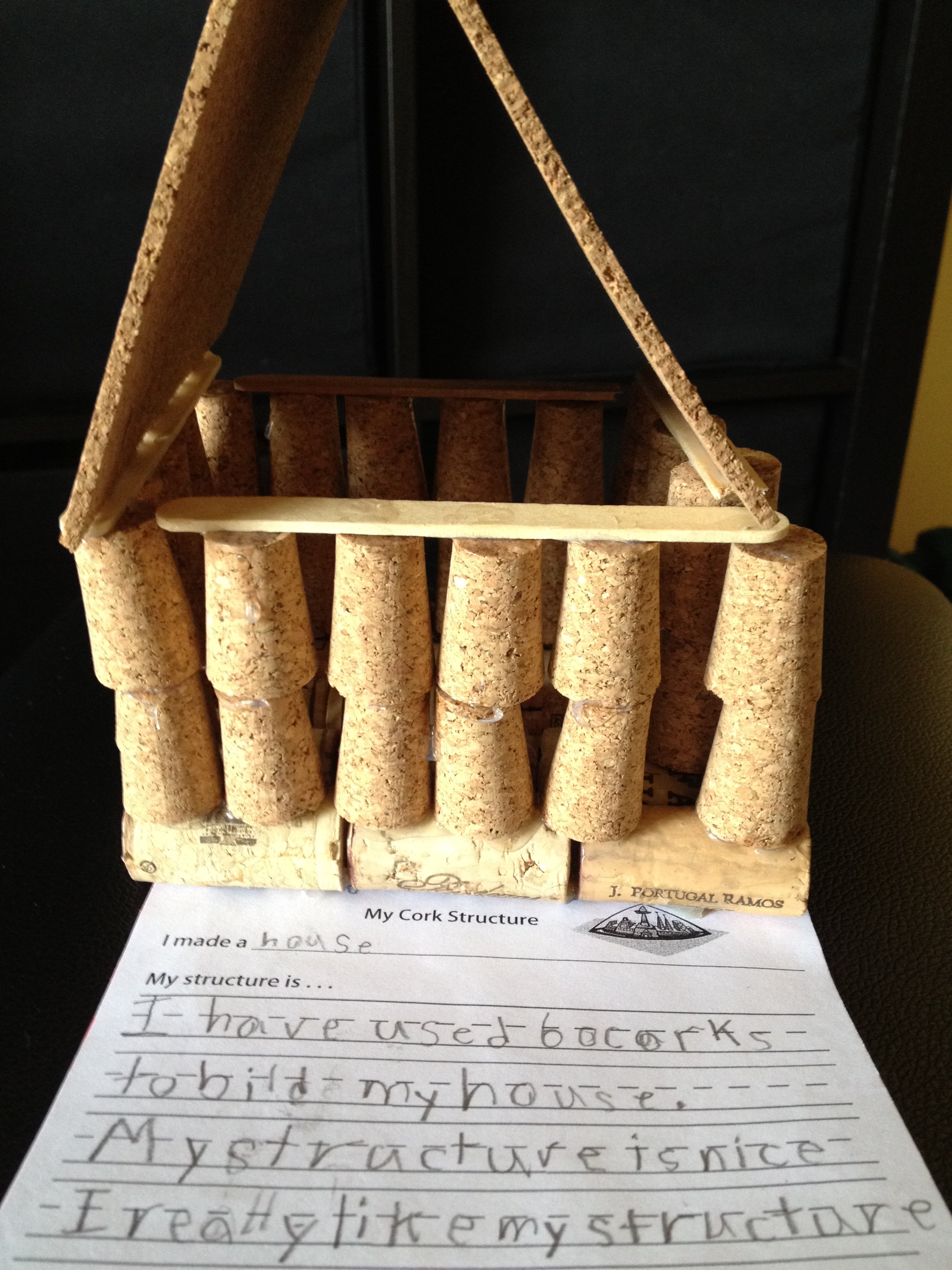 Wine corks and cork sheets create a tiny cork house made by a young student