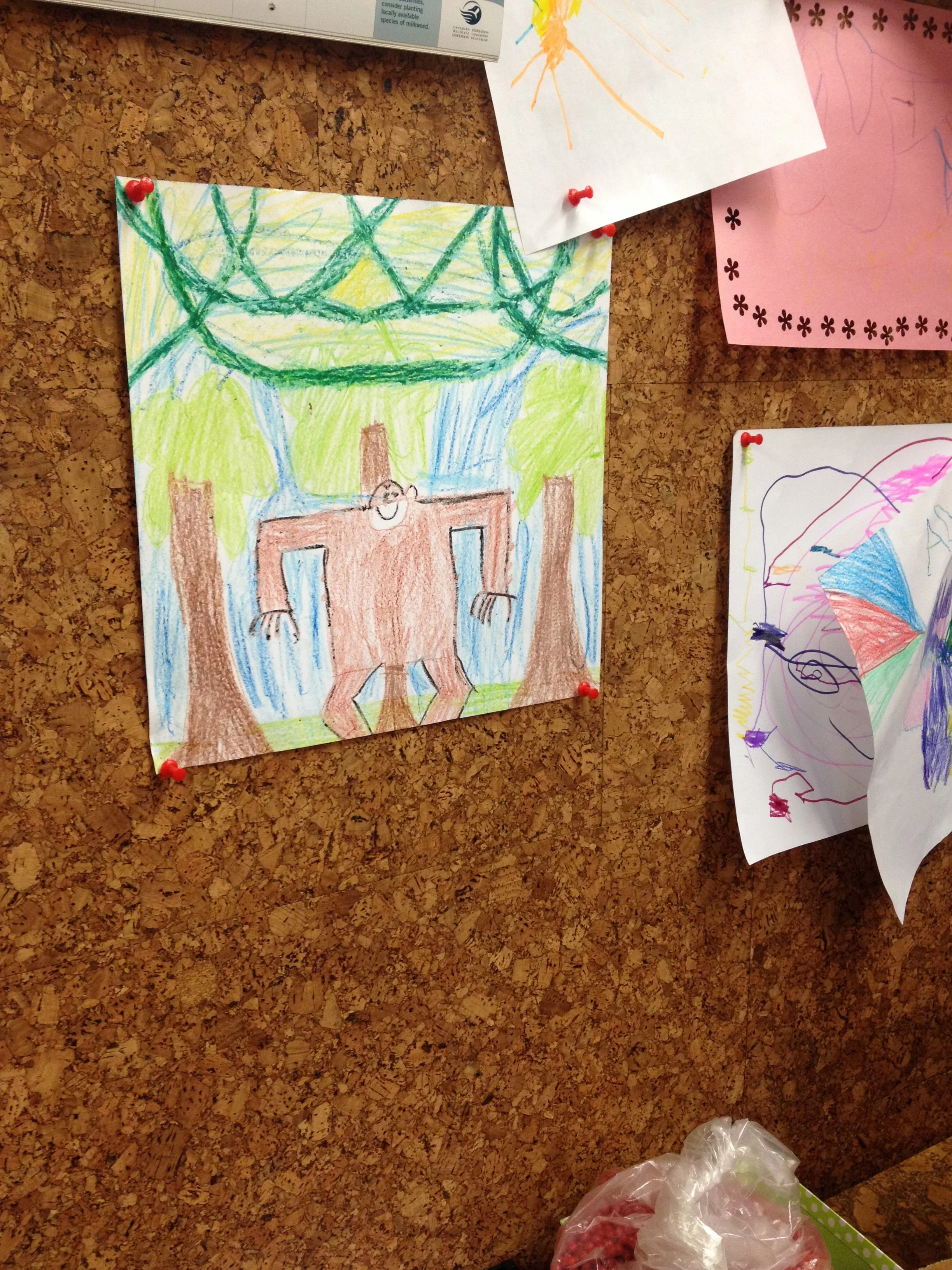 Kids artwork pinned to a cork wall