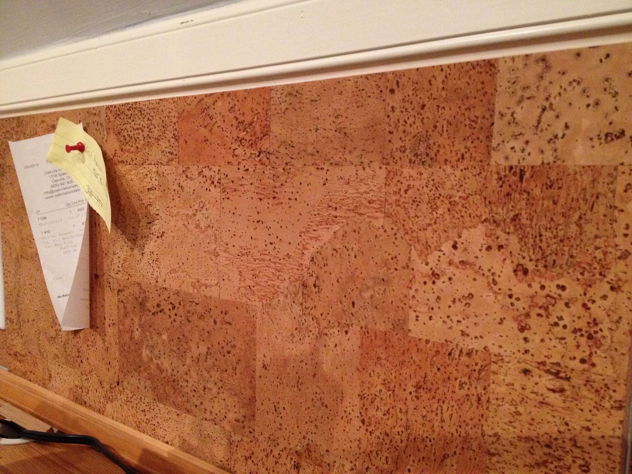 Thick cork wall tile with notes pinned to it shows the thickness of the cork tile