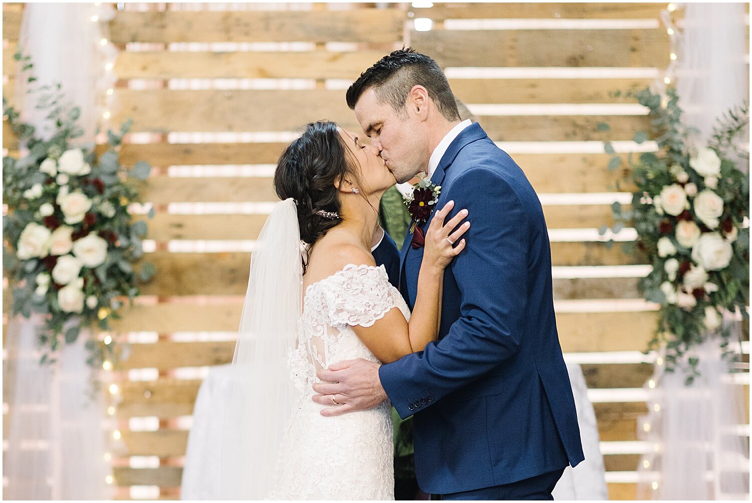  bride and groom kiss during their wedding ceremony 