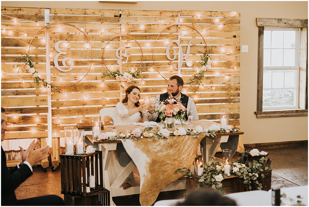  bride and groom sitting at their sweetheart table 