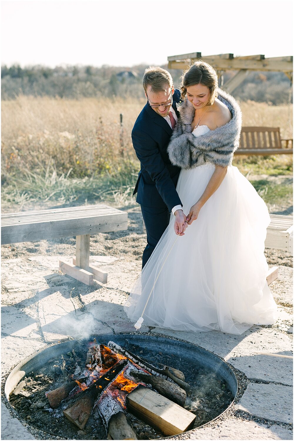  bride and groom having marshmellows by the firepit 