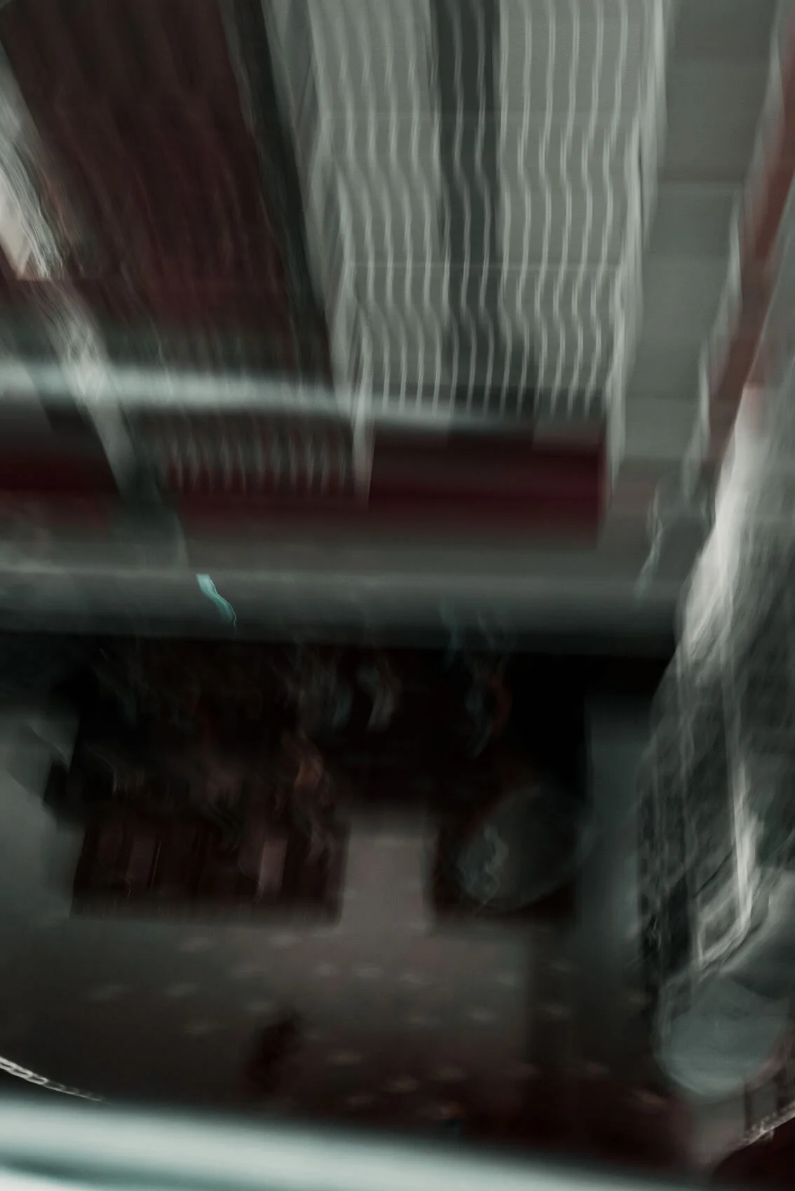 Taken with slow shutter speed in moving glass elevator lines of architecture and furniture blur in red, blue, white, and silver. Atlanta, Georgia.