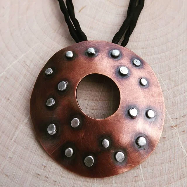 Copper “shield” pendant with sterling silver rivets.
