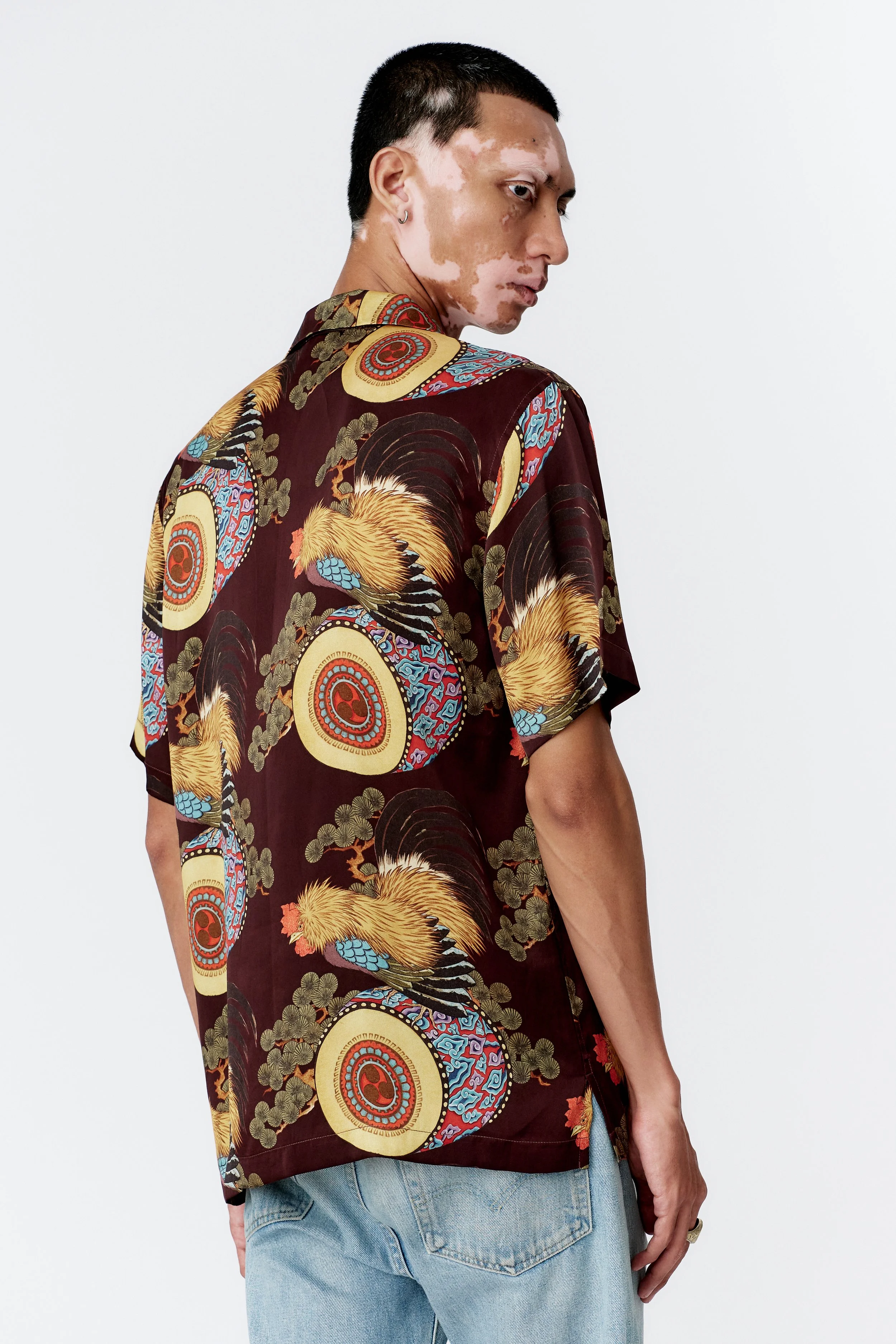 Angled Side profile of model wearing Rooster Drum Wine silk shirt with straight hem.