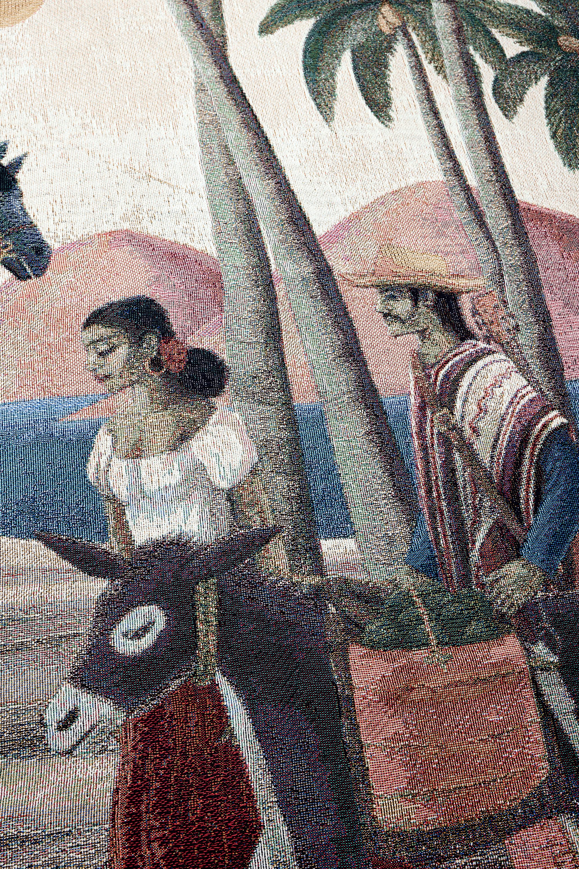 Detailed view of cowboy in poncho and woman on the Bandito woven art blanket.