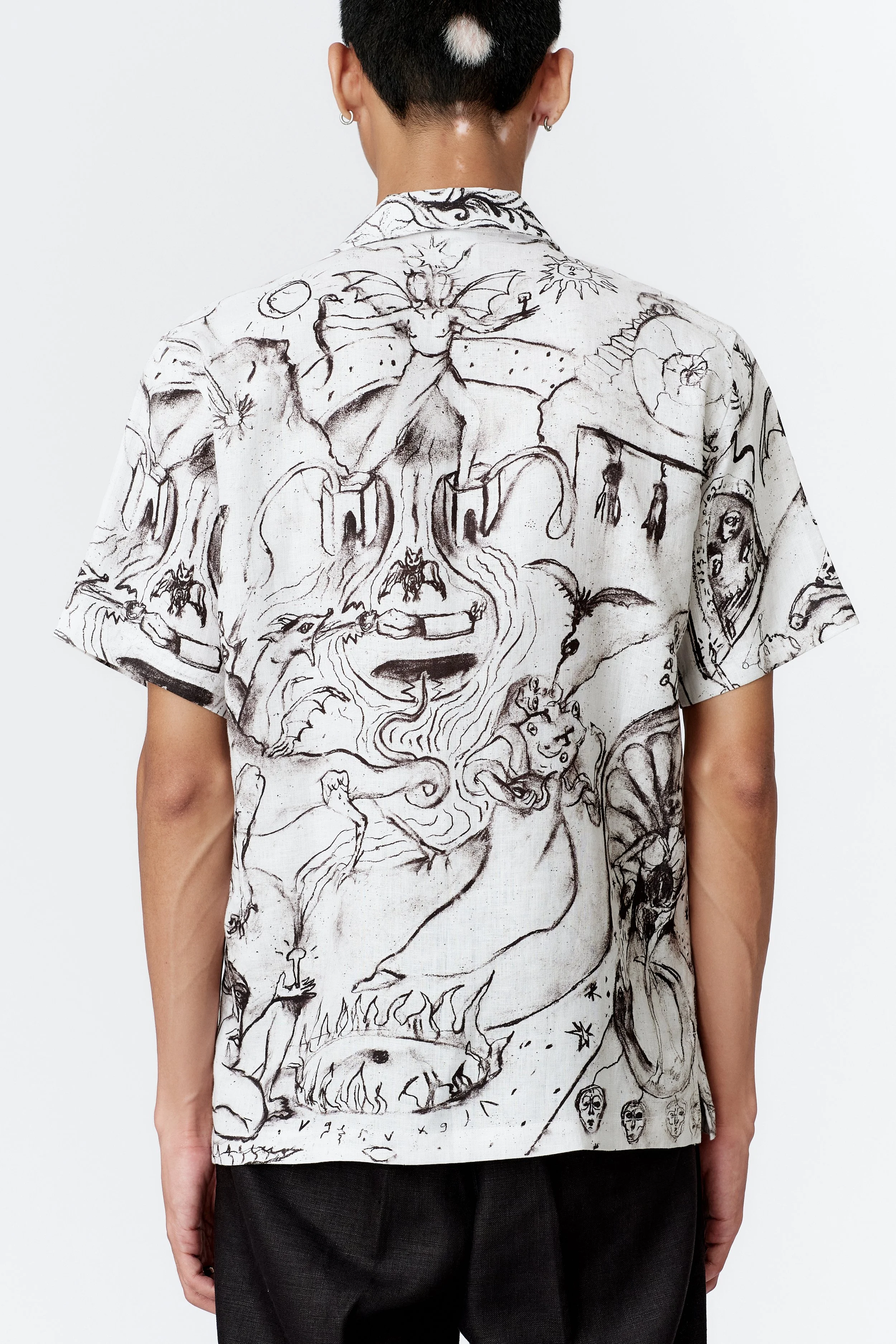 Back view of ALCHEMY linen short sleeve shirt highlighting continuation of surreal artwork