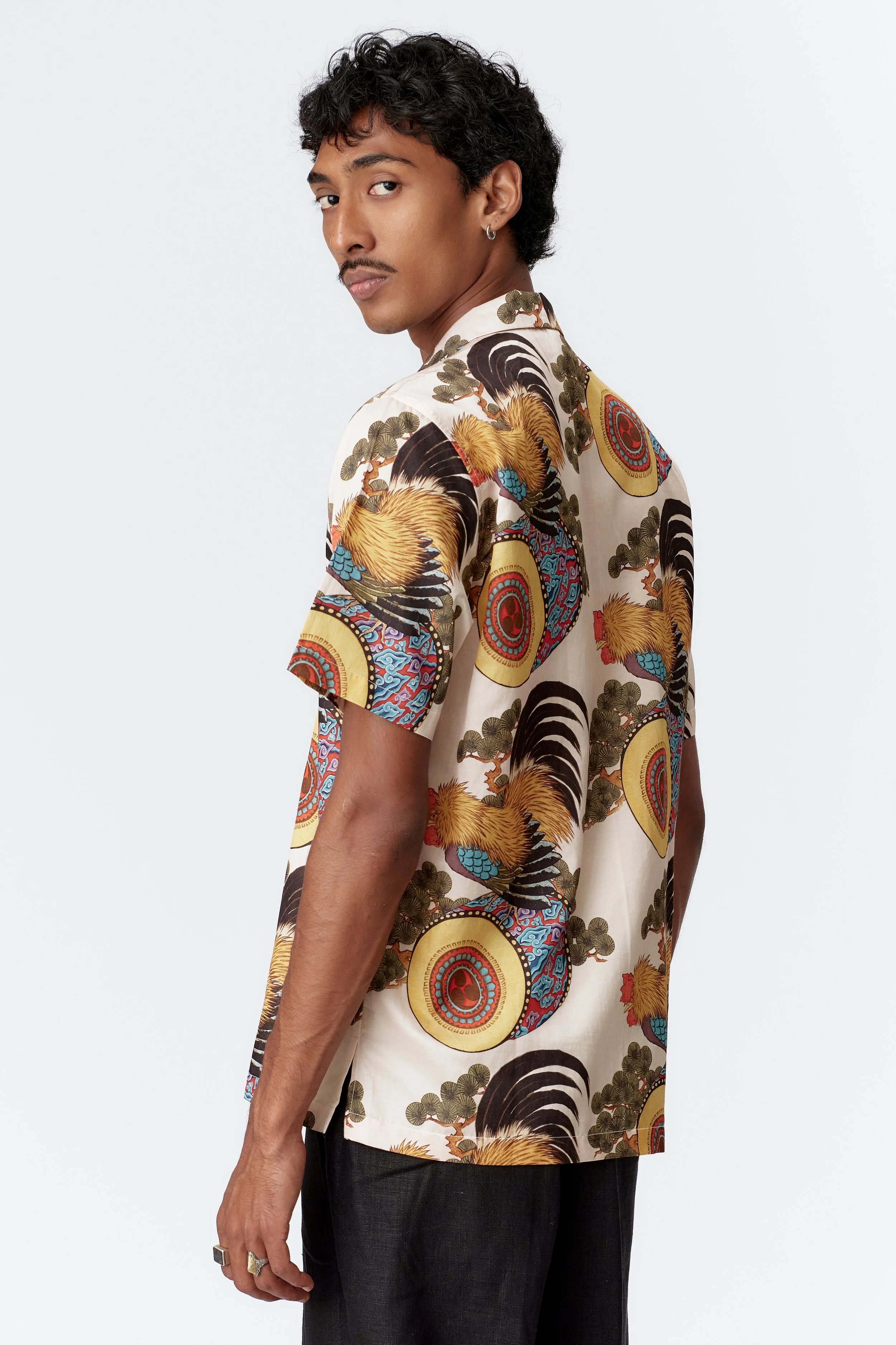 Side profile of model wearing Rooster Drum cream short sleeve shirt with straight hem