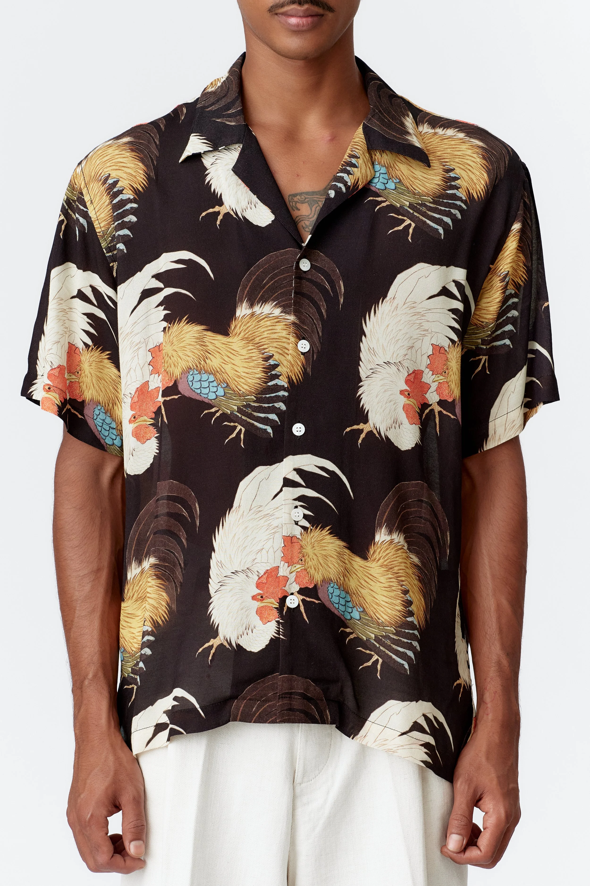 Close-up detail of rooster feathers in vivid multi-colour on black crepe rayon fabric