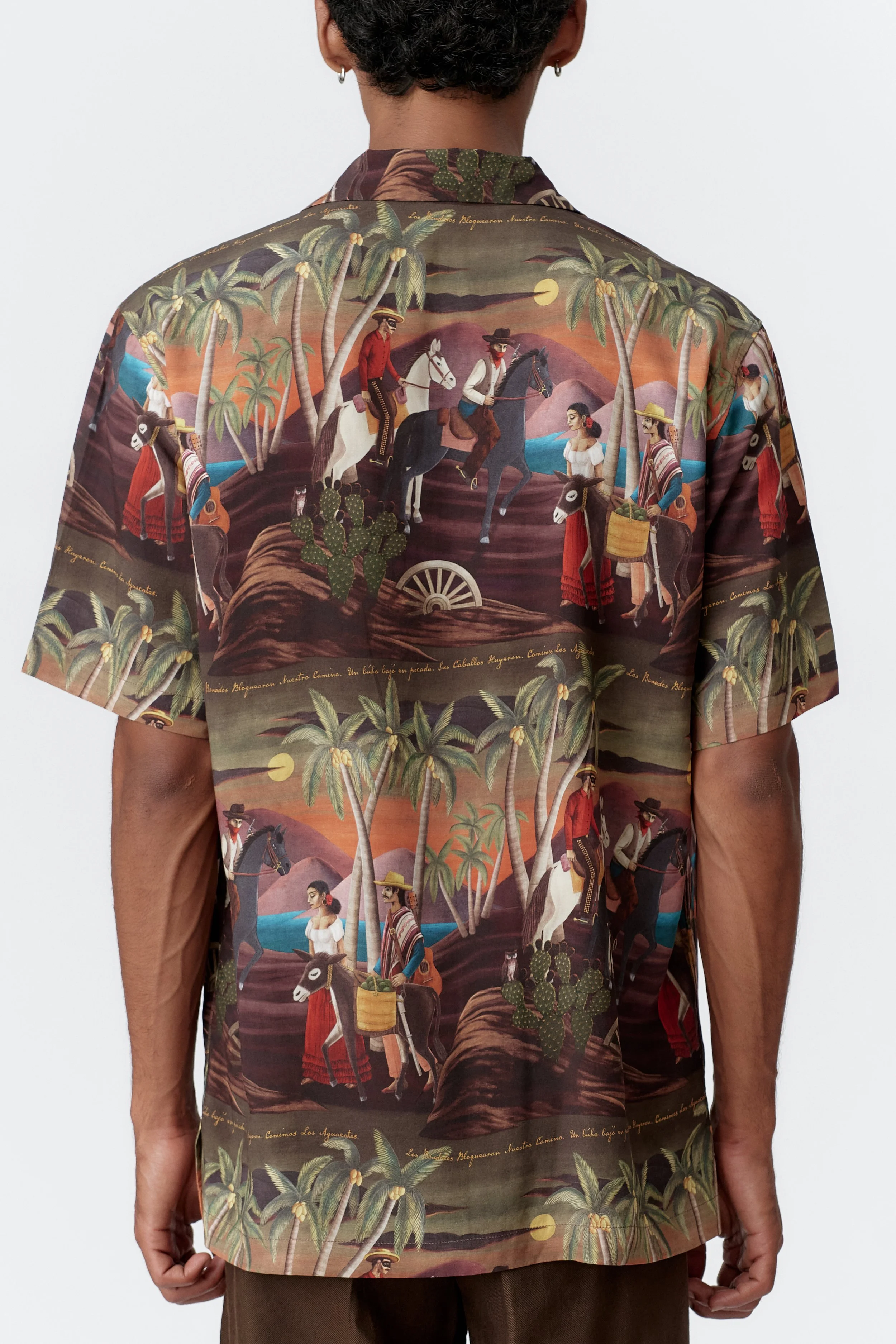 Fabric texture close-up behind highlighting all-over Bandito repeat pattern on bottle green base