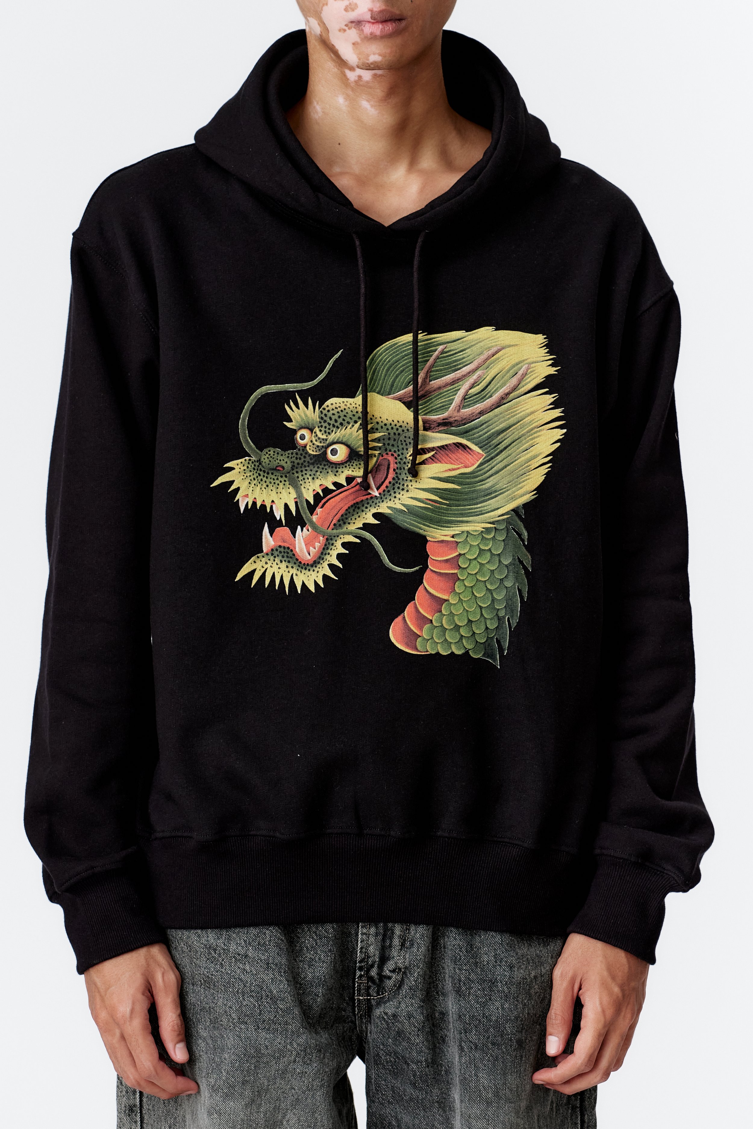 Detailed view of bristling scales, sharp fangs, and yellow whiskers on dragon graphic