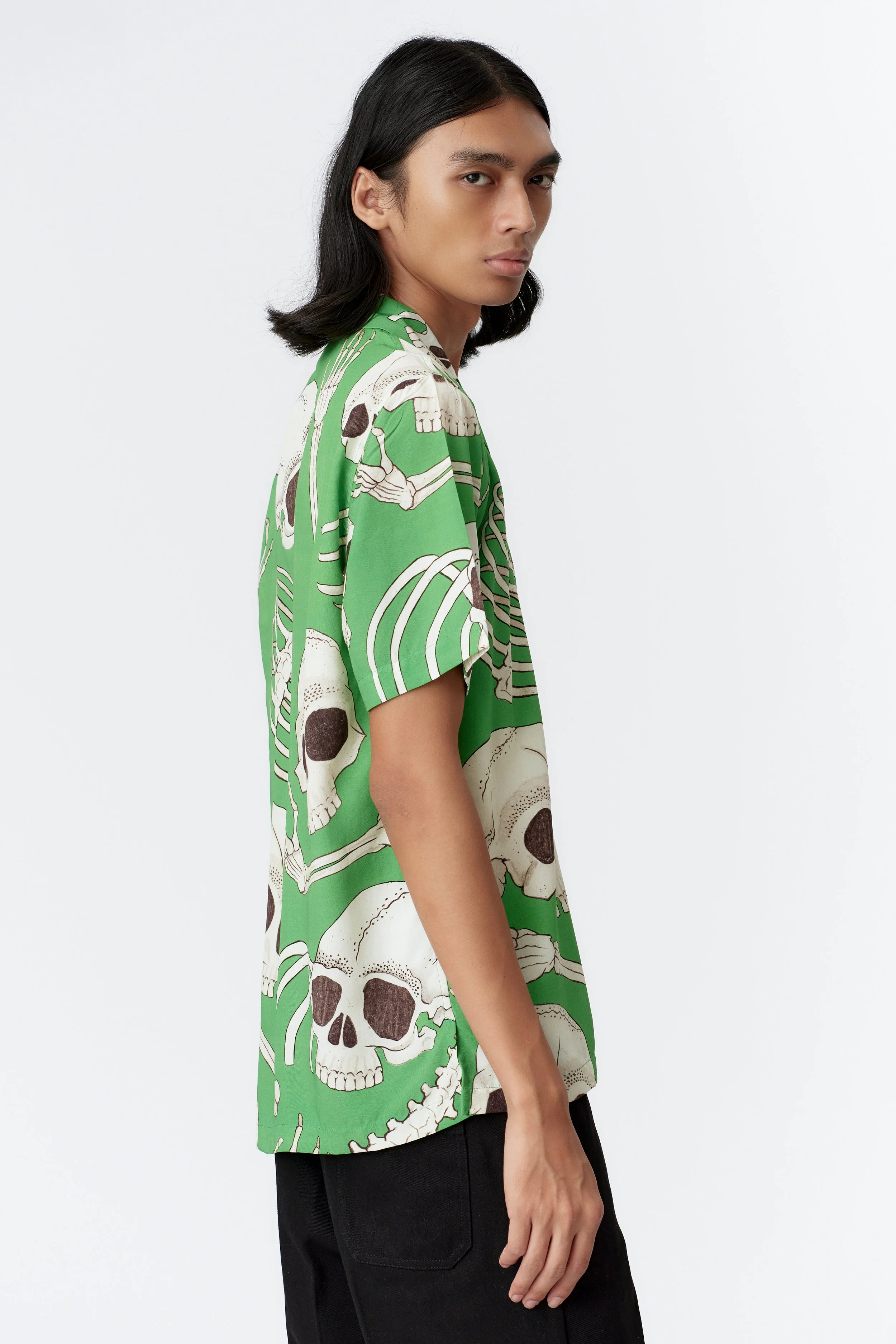 Side profile of model wearing Skeleton green short sleeve shirt with straight hem