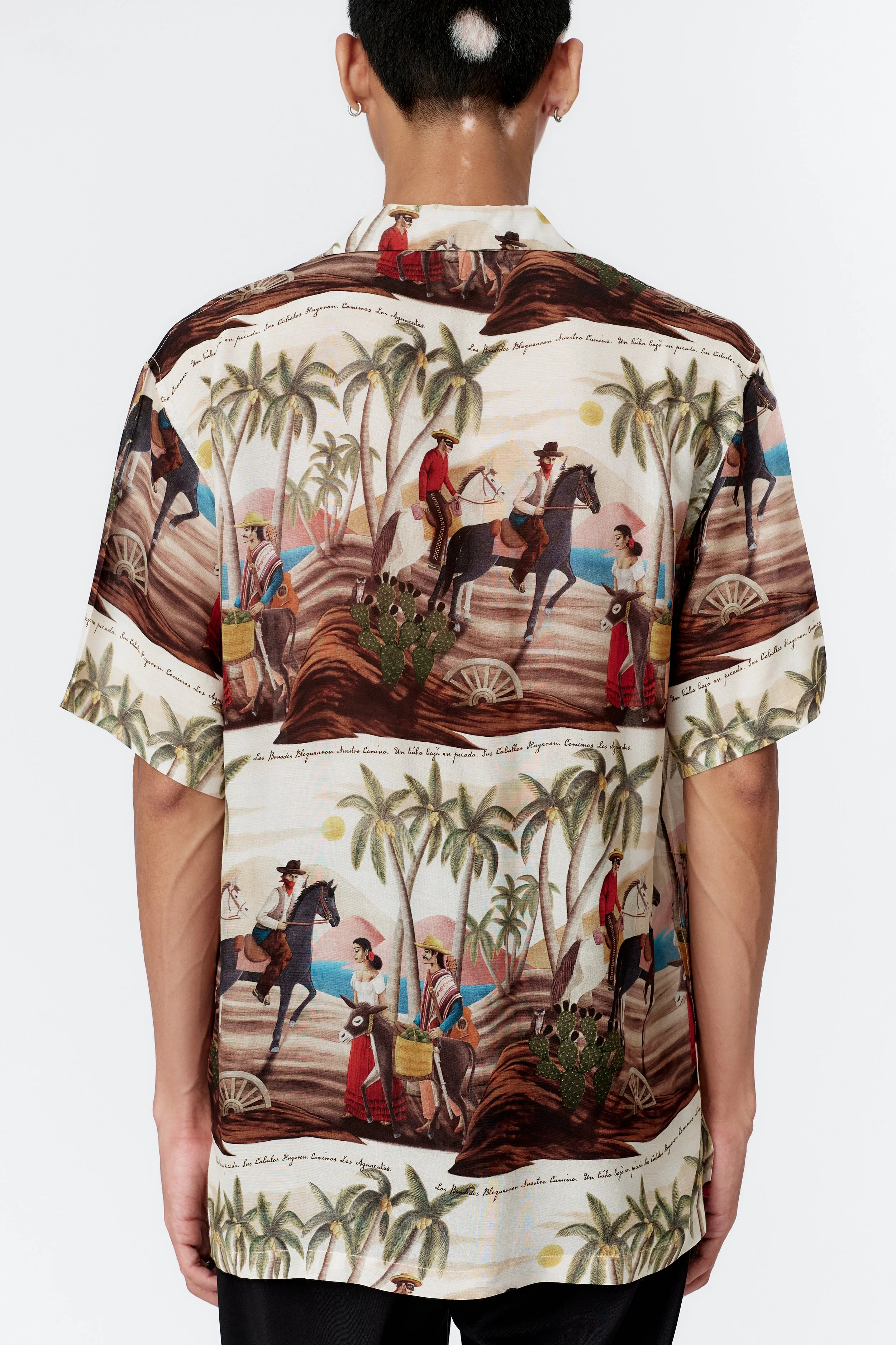 Fabric texture close-up from behind highlighting smooth silk rayon blend with off white base and vivid western artwork