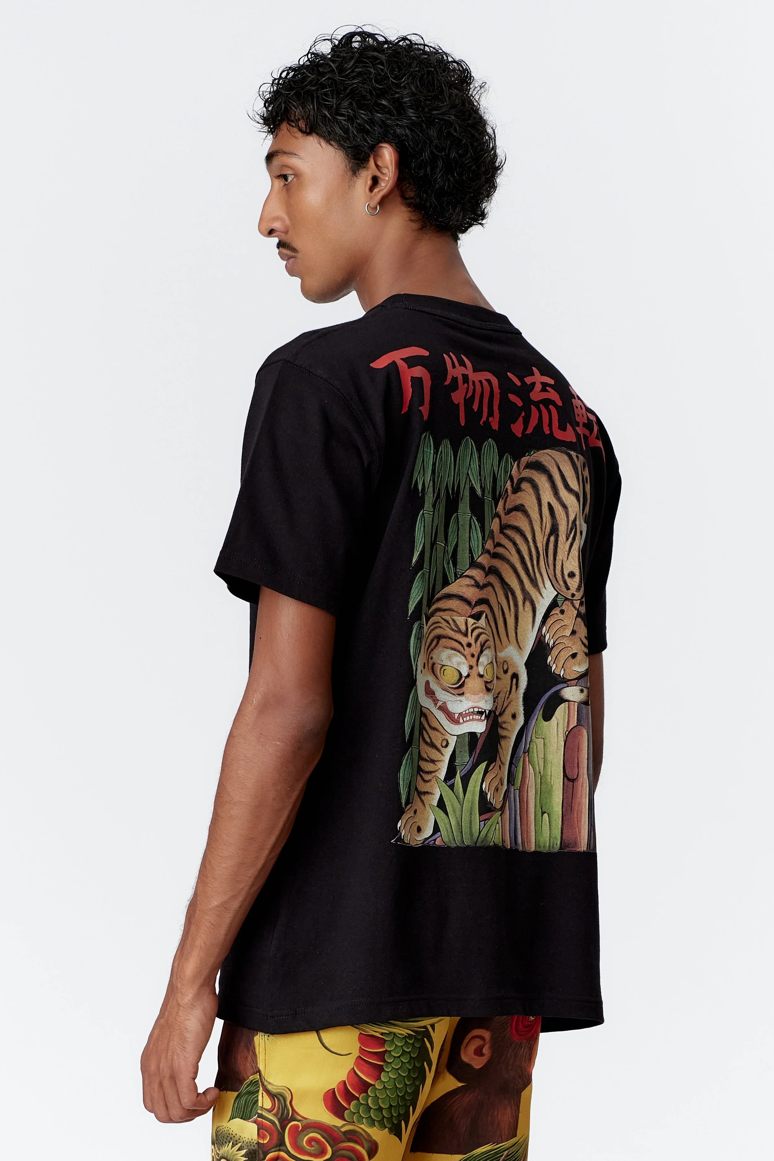 Side profile of model wearing Tiger black heavyweight organic cotton T-shirt