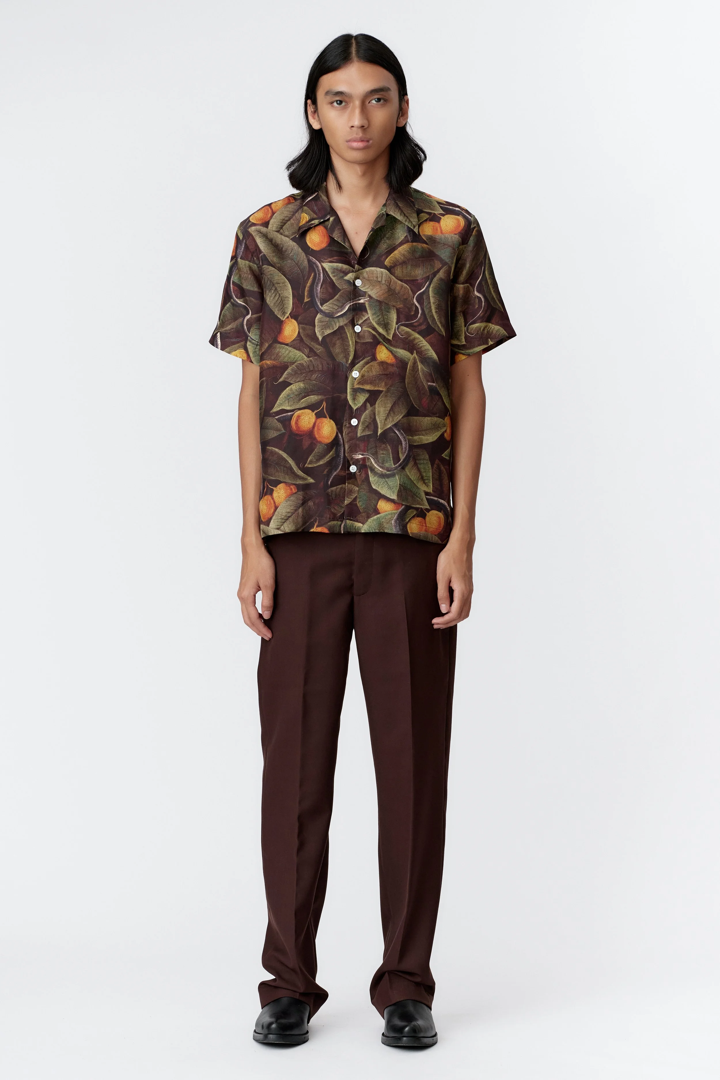 Model wearing SNAKER 100% silk satin short sleeve shirt featuring original Stevie Anderson artwork of sacred serpents