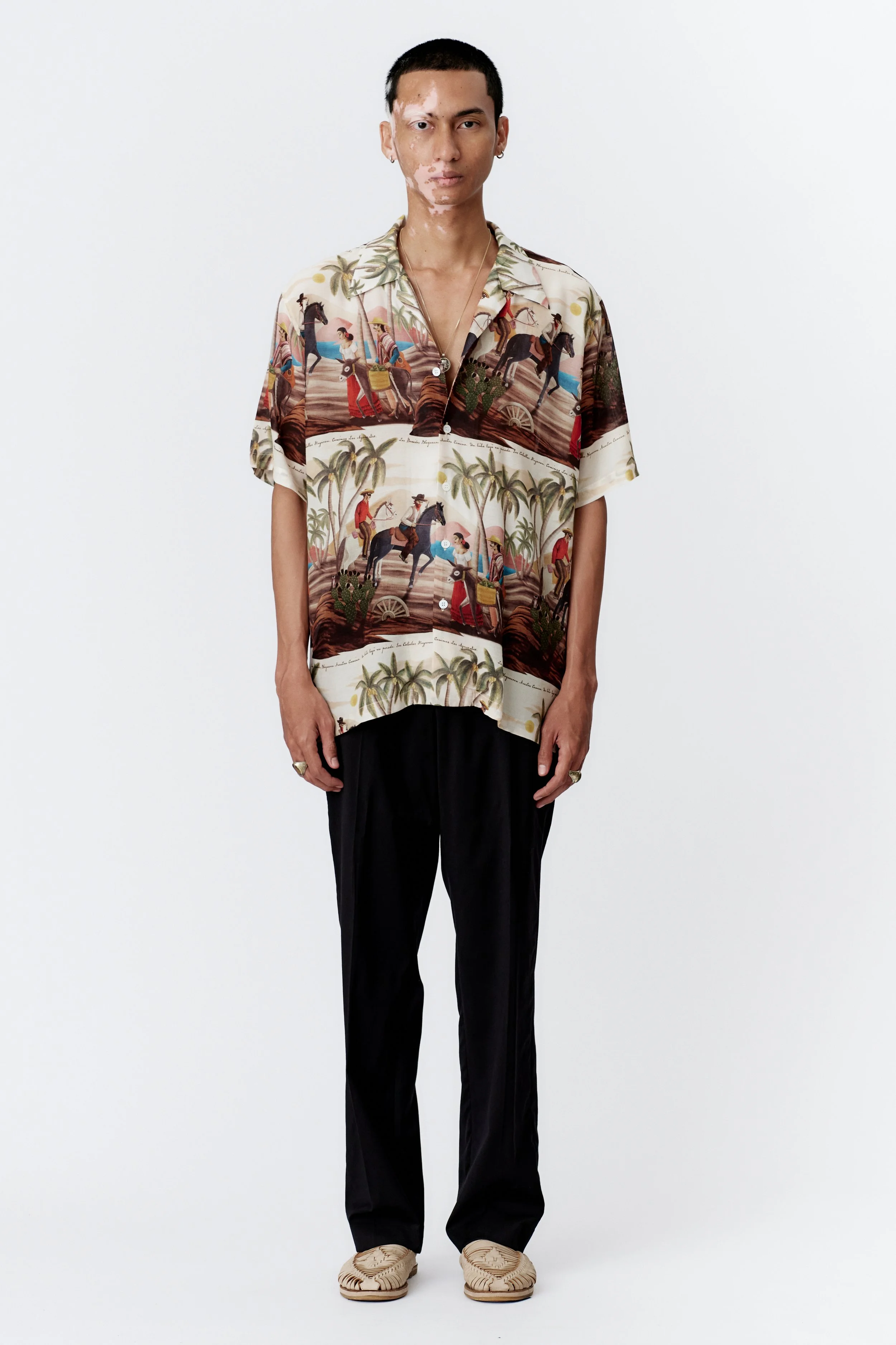 Full front view of Bandito Repeat Off White silk rayon short sleeve shirt featuring an all-over surreal desert western artwork on an off white base