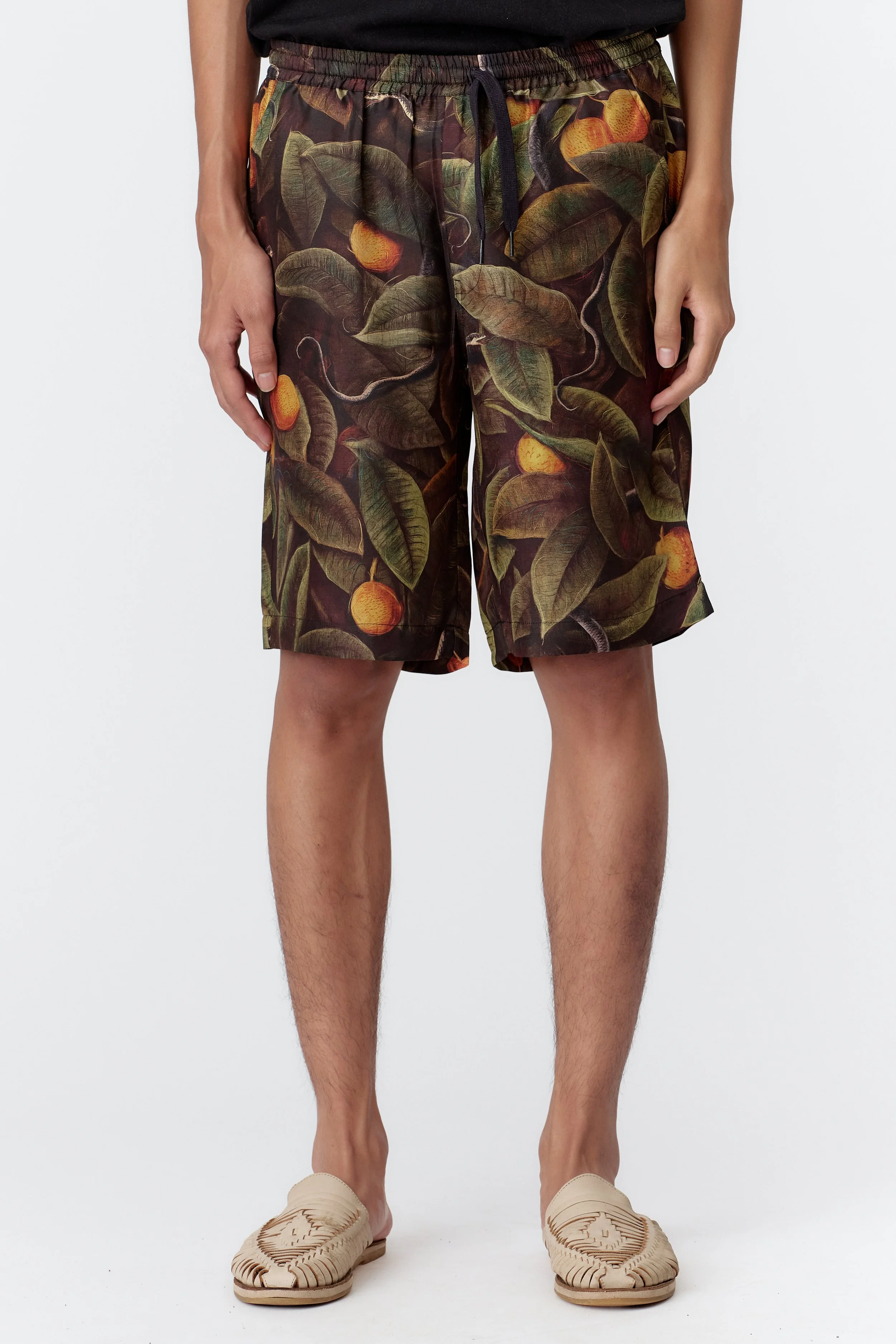 Model wearing Snaker limited edition 100% silk satin twill short sleeve shirt featuring green foliage and silver serpents