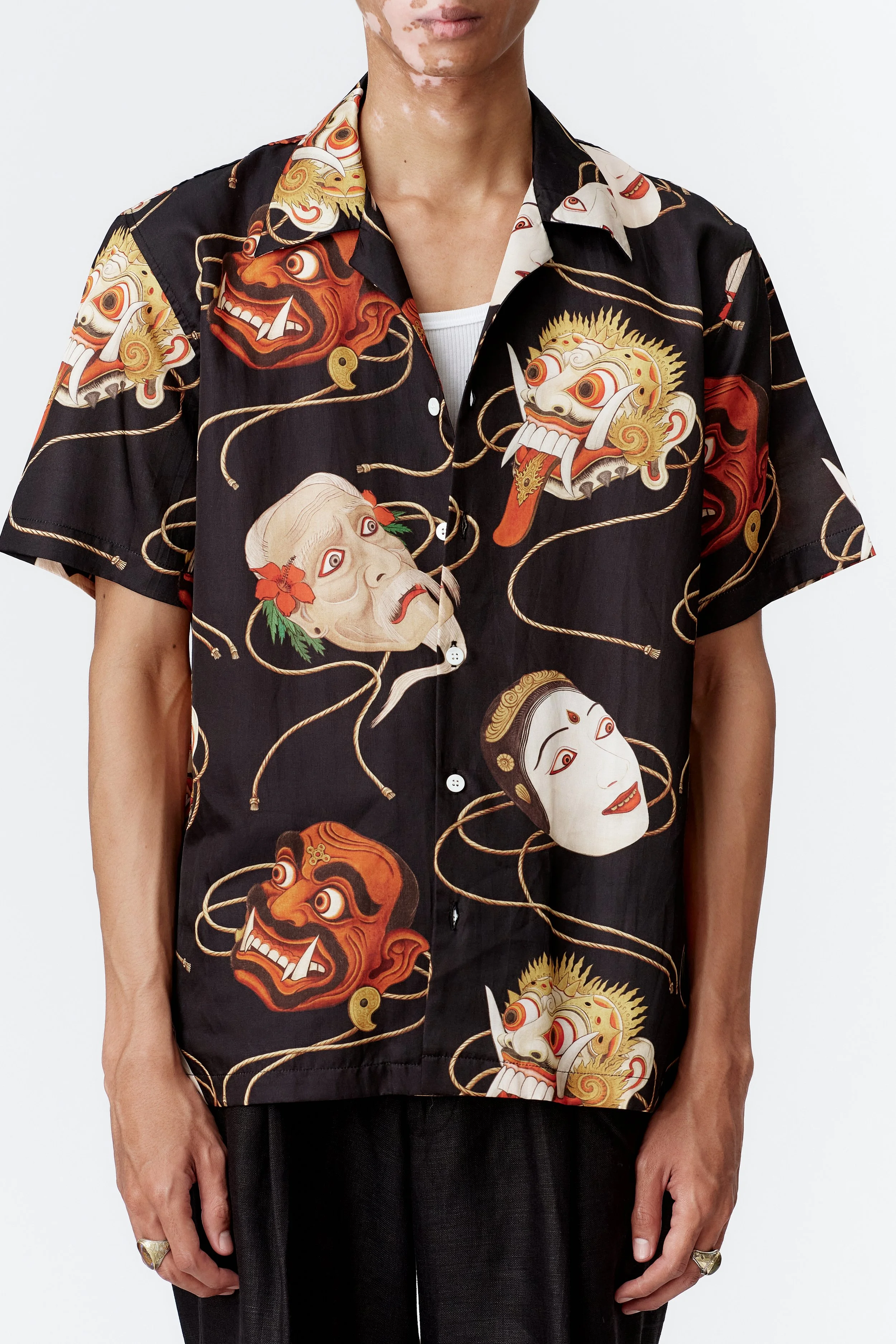 SS26 Topeng Black short sleeve shirt close-up featuring Balinese mask artwork