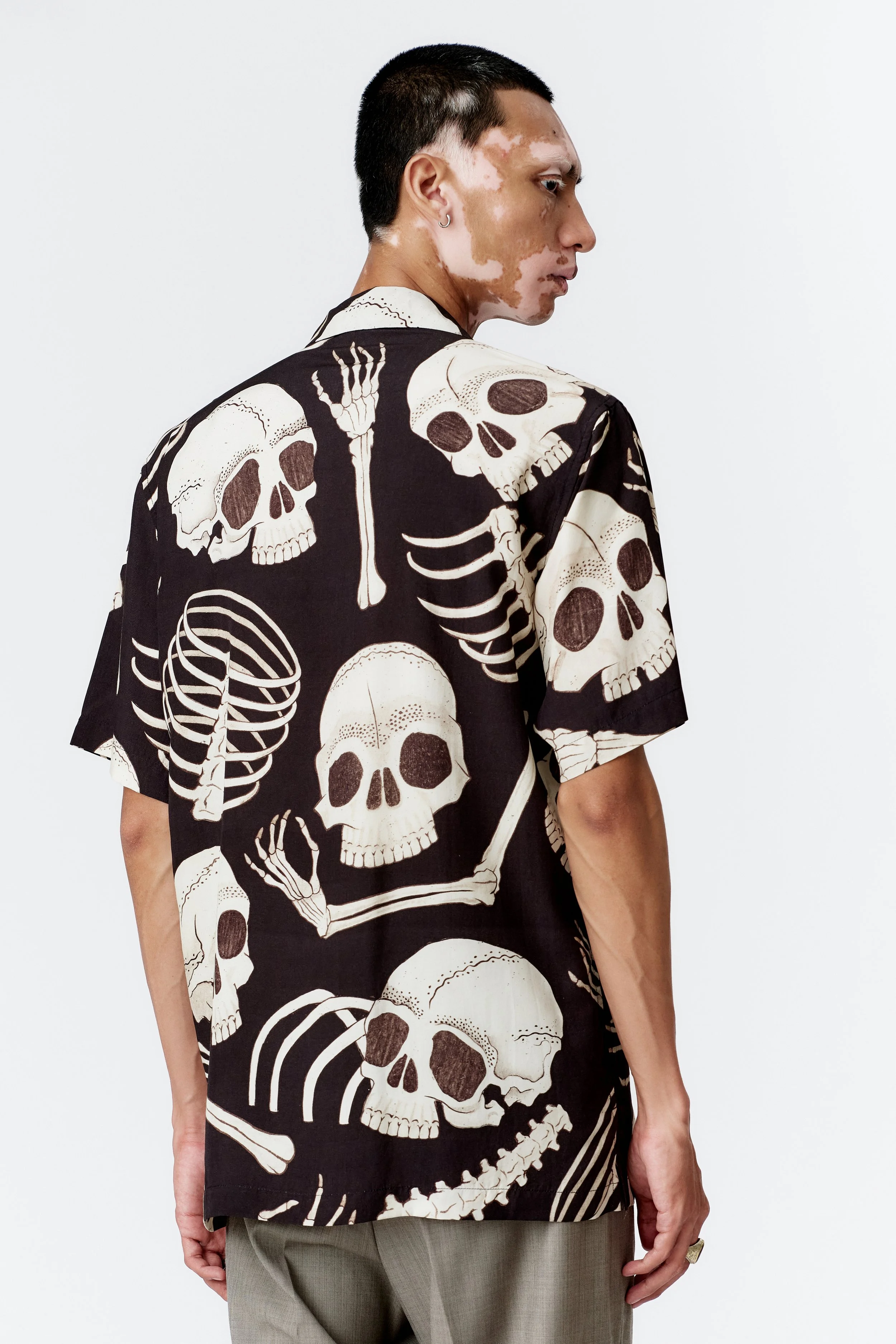 Side profile of model wearing Skeleton black short sleeve shirt with straight hem
