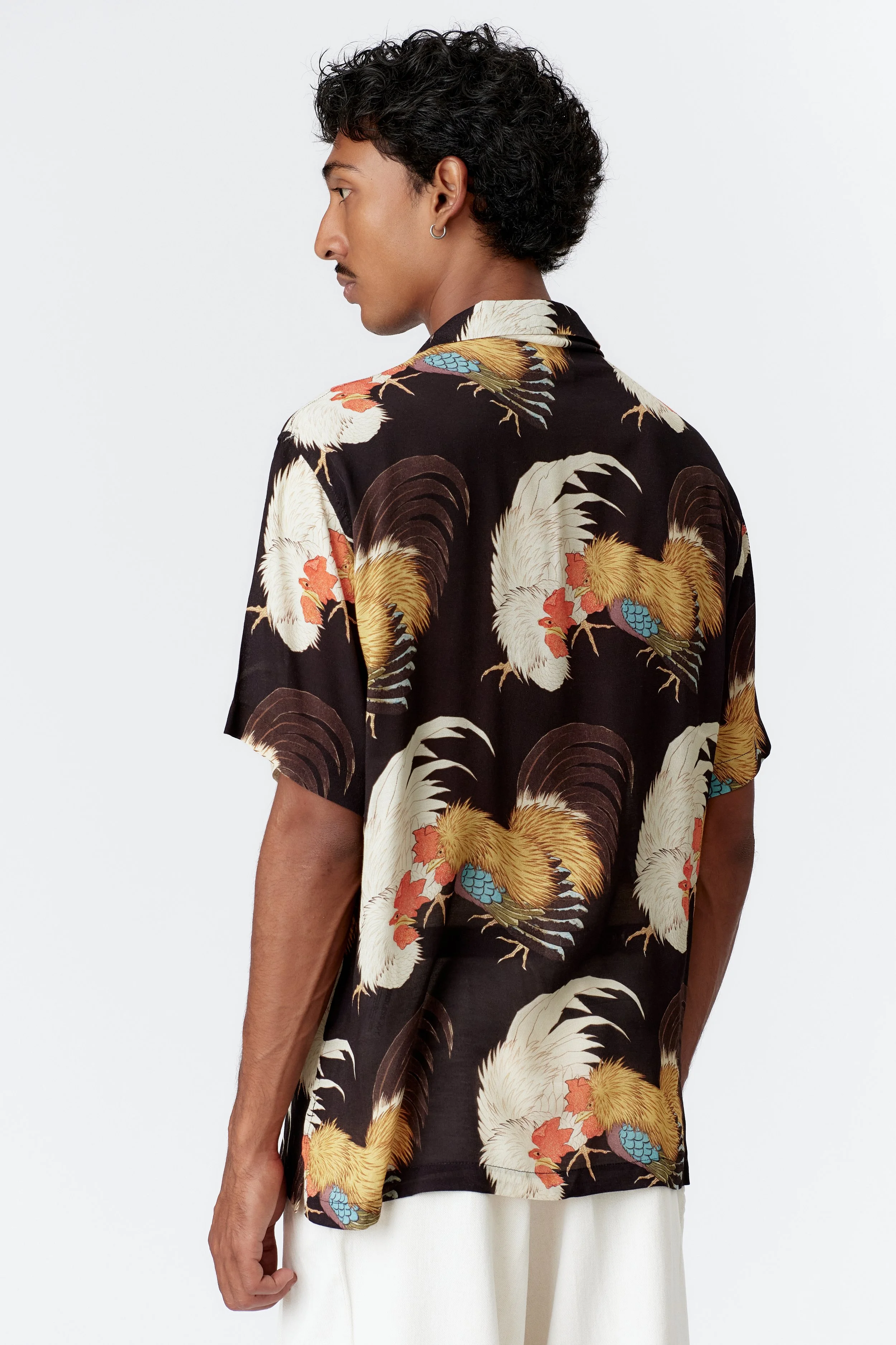 Side profile of model wearing Rooster black short sleeve shirt with straight hem
