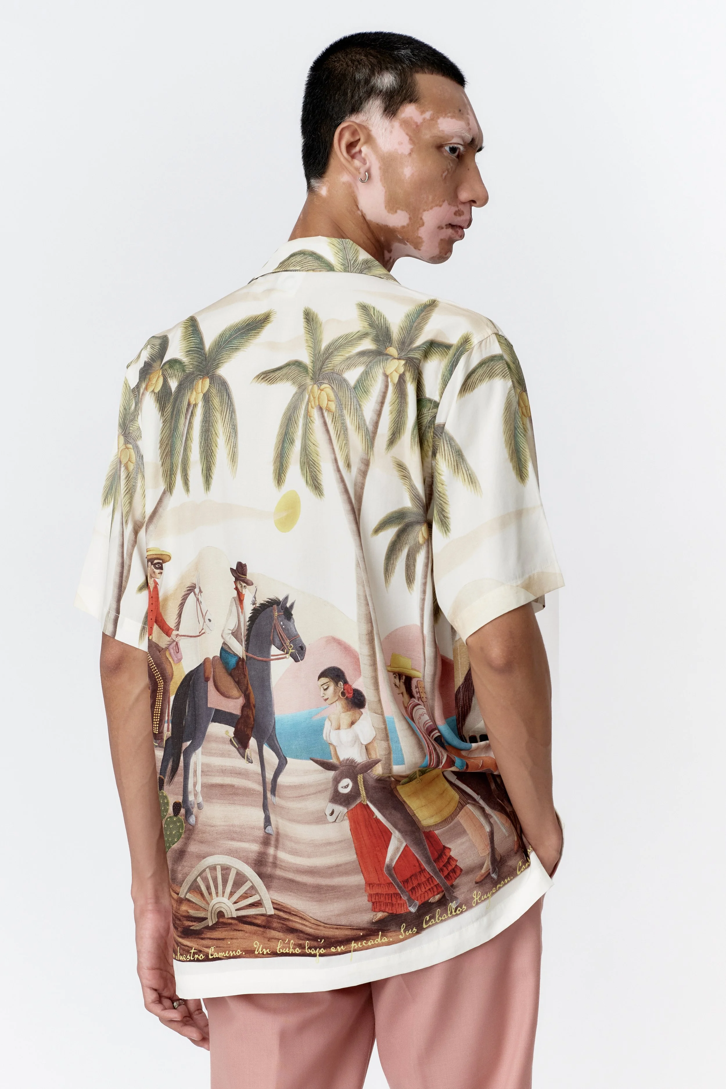 Behind on Side profile of model wearing off white Bandito camp collar shirt with straight hem