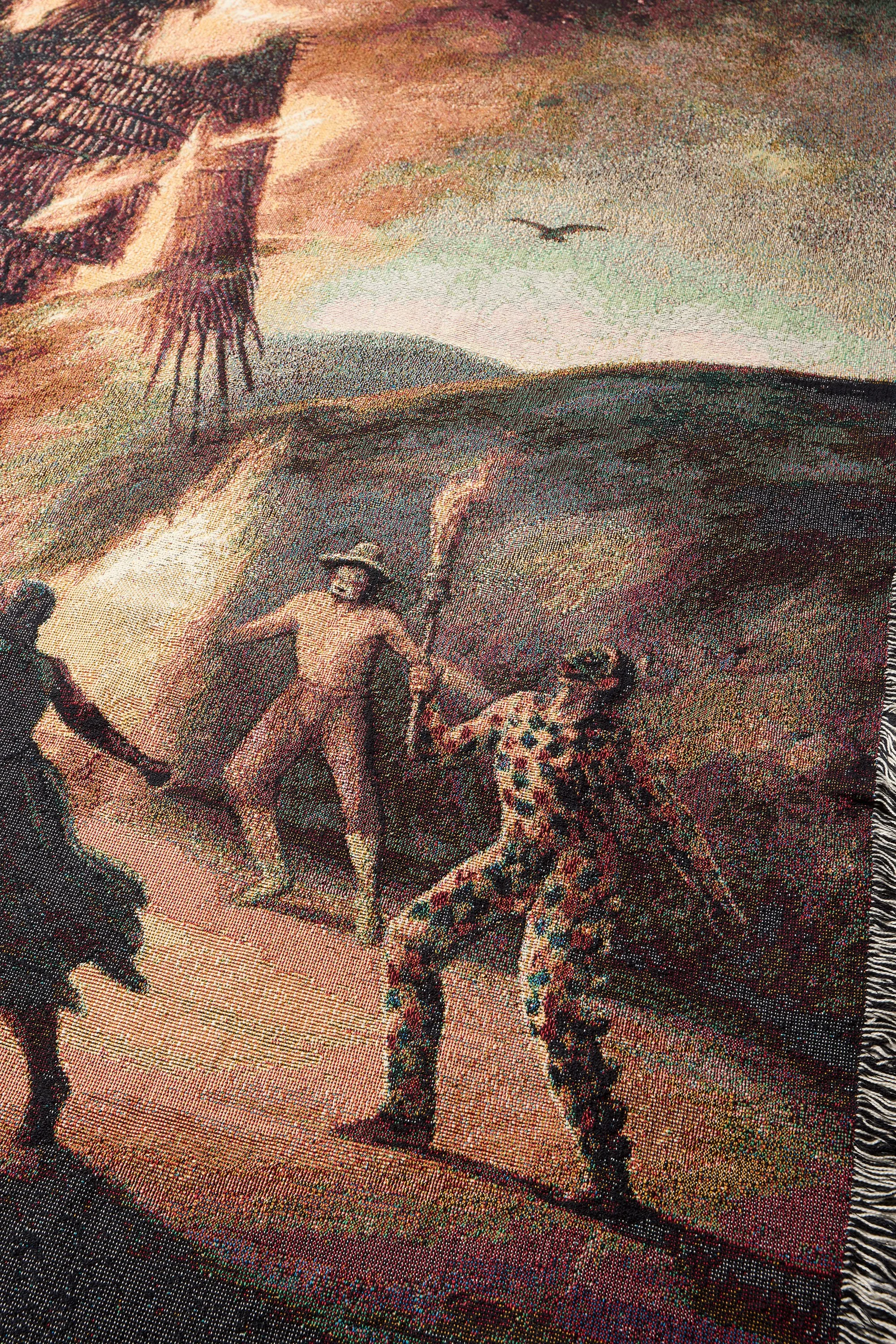 Close-up of burning wicker effigy and masked figures woven into blanket