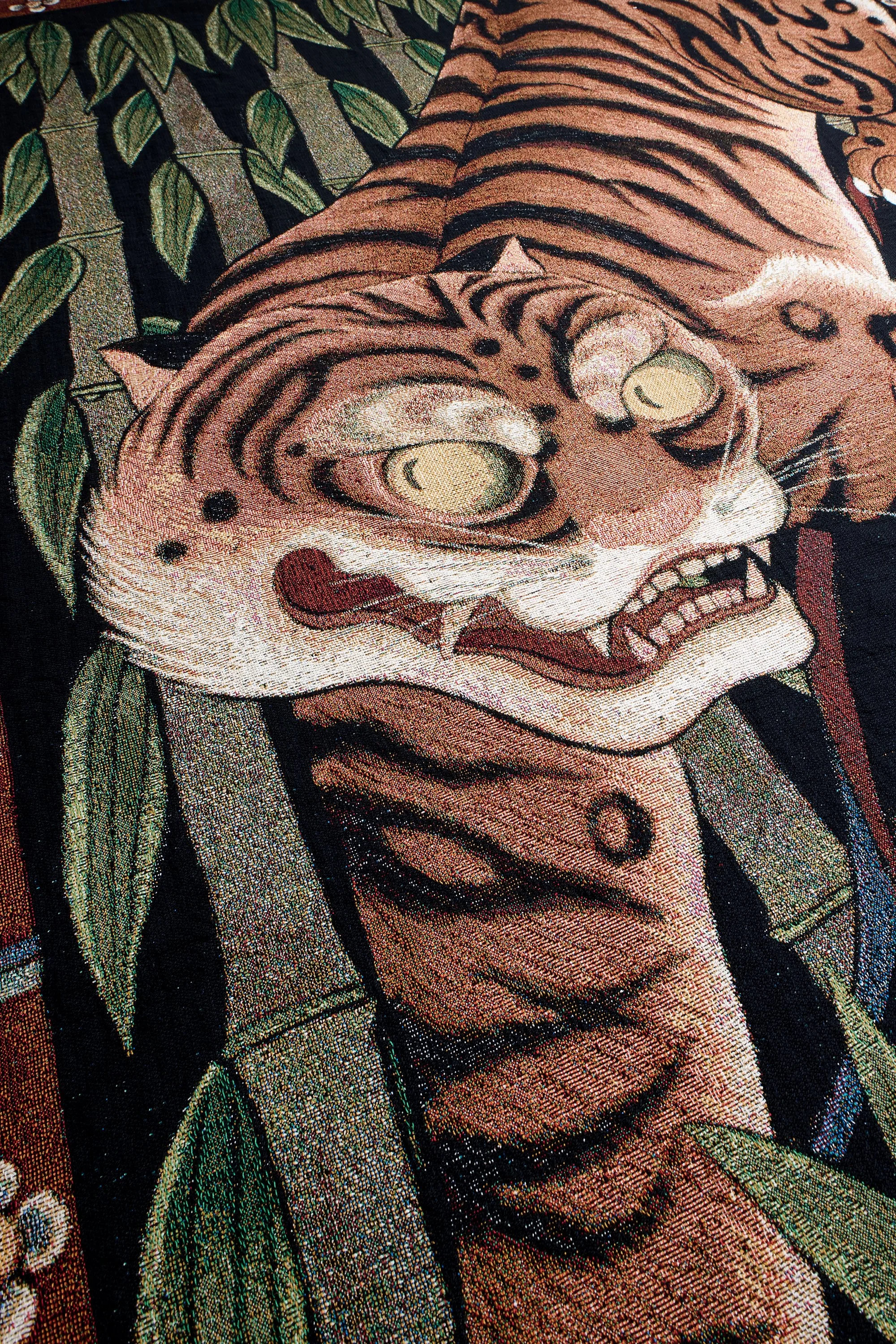 Close-up of bright orange tiger with yellow eyes woven into blanket