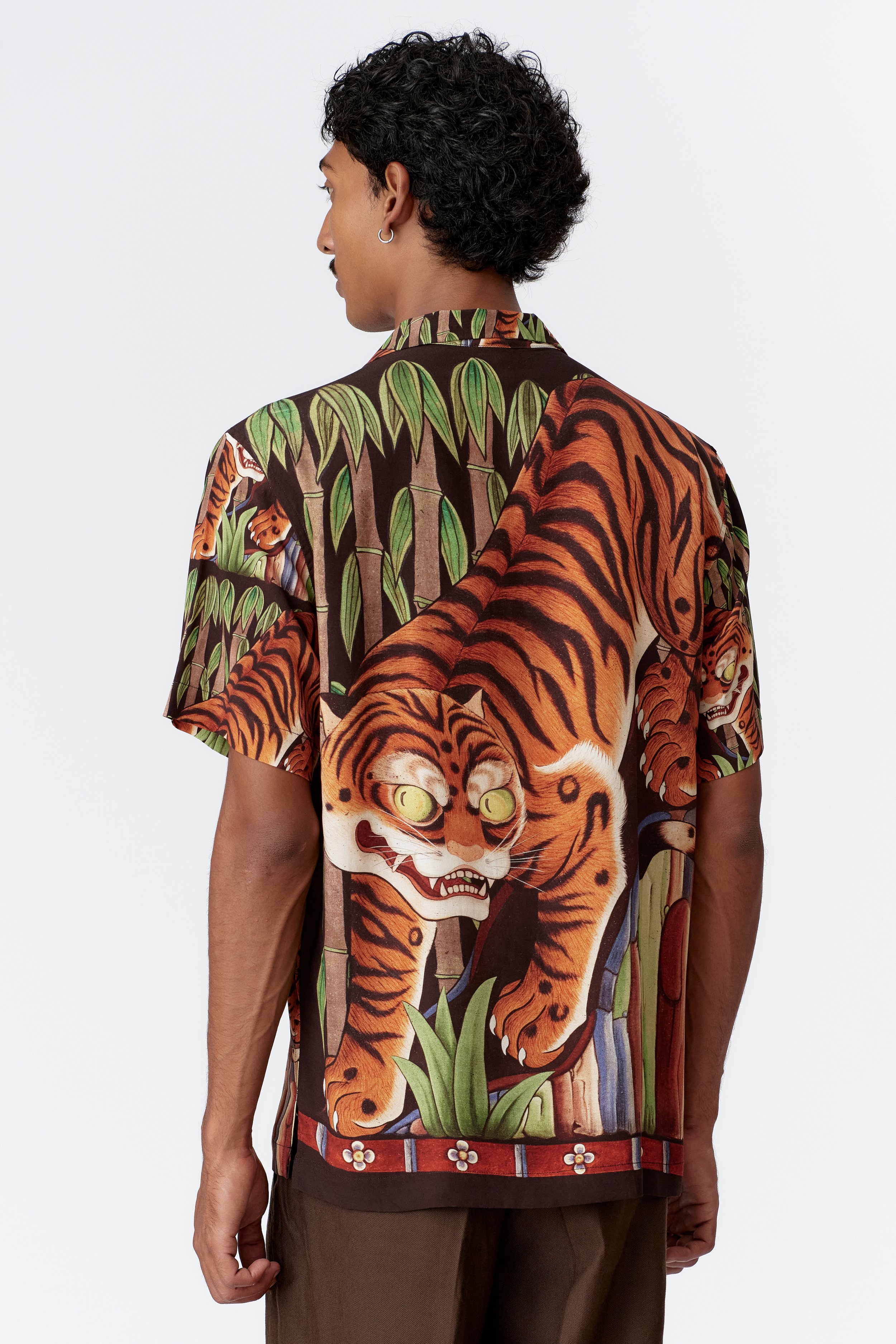 Back view of Tiger black short sleeve shirt featuring large prowling tiger artwork  Side profile of model wearing Tiger black premium rayon shirt with straight hem