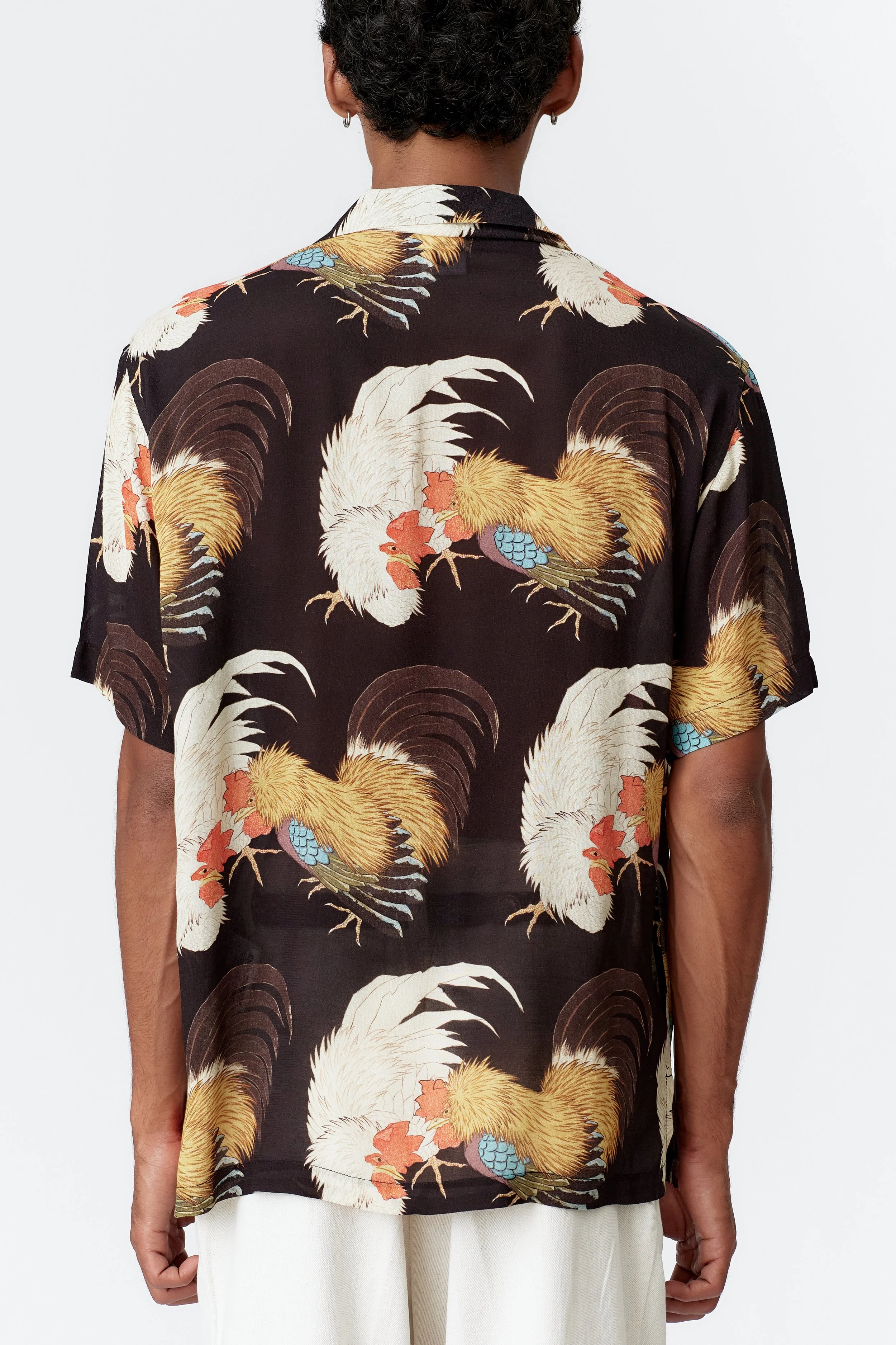 Back view of Rooster black camp collar shirt featuring two roosters rising against dark background