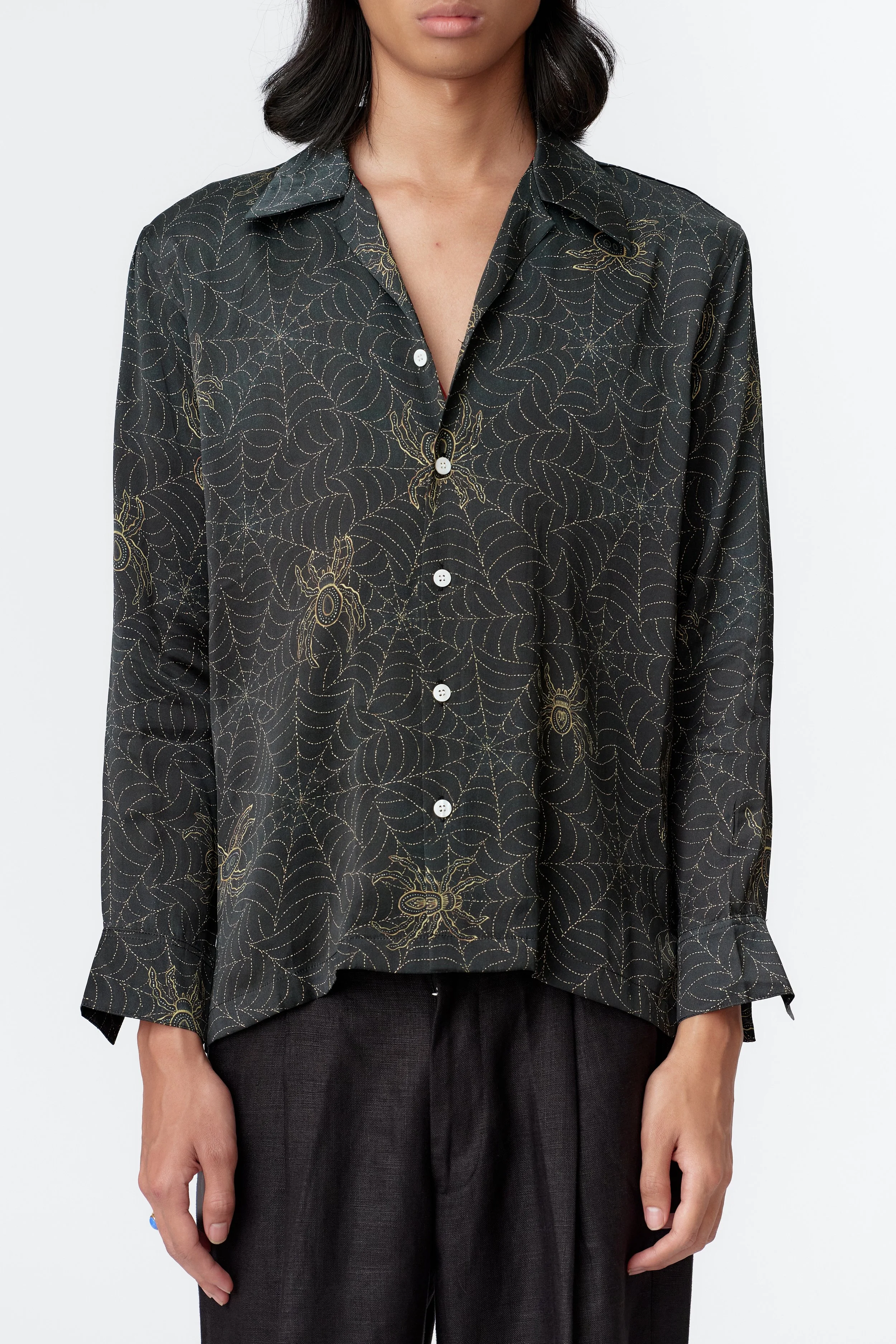 Close-up of hand-rendered batik-style pointillism web artwork in gold on indigo silk satin fabric.